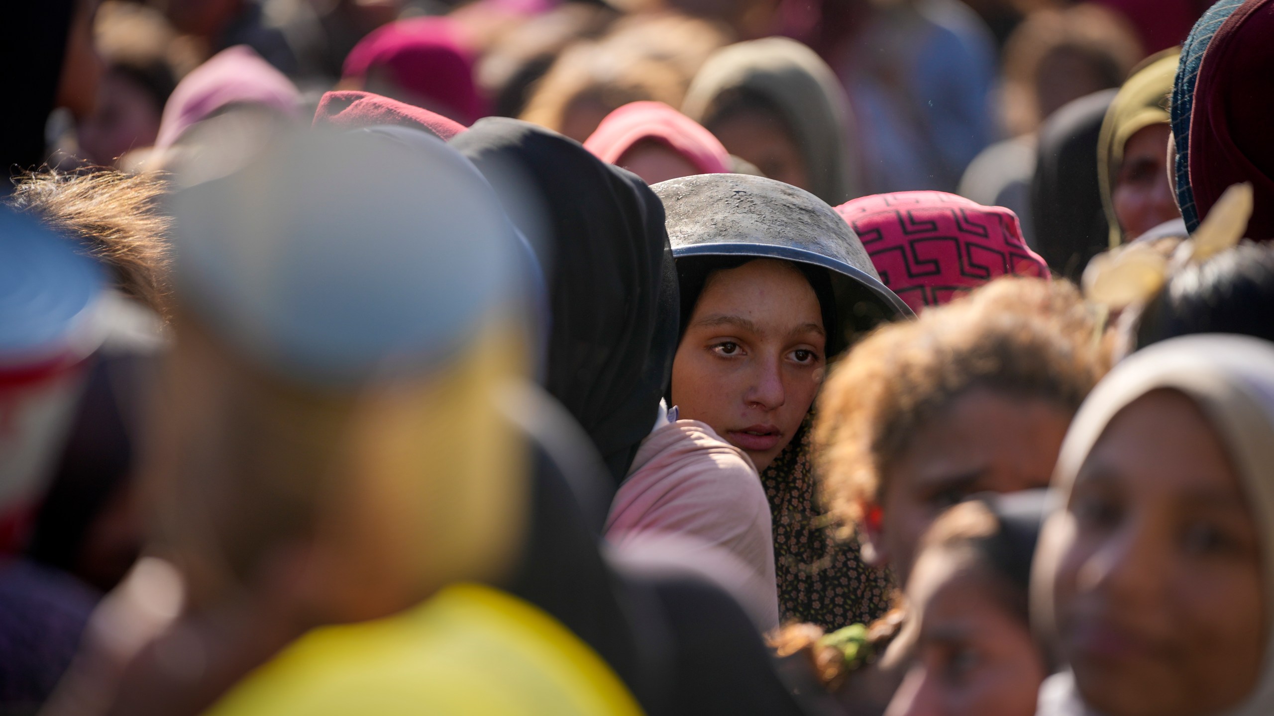 Palestinian children wait in line for food at a distribution center in Deir al-Balah, Gaza Strip, Tuesday, Dec. 17, 2024. (AP Photo/Abdel Kareem Hana)