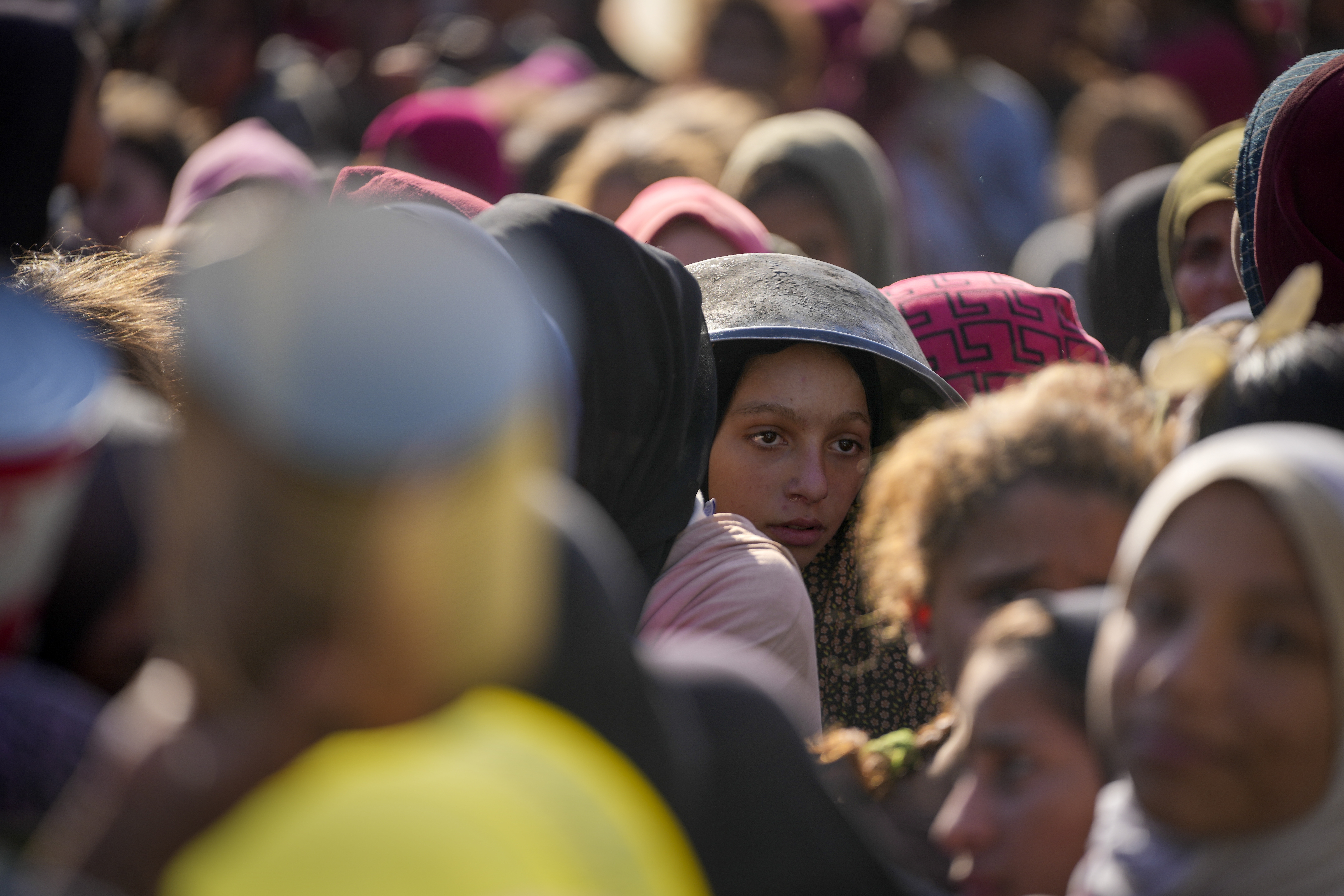 Palestinian children wait in line for food at a distribution center in Deir al-Balah, Gaza Strip, Tuesday, Dec. 17, 2024. (AP Photo/Abdel Kareem Hana)