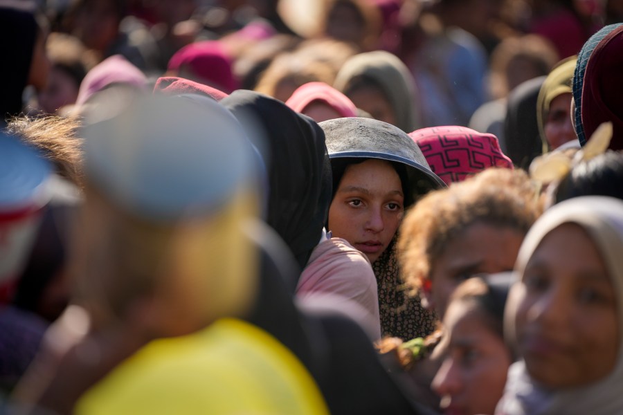 Palestinian children wait in line for food at a distribution center in Deir al-Balah, Gaza Strip, Tuesday, Dec. 17, 2024. (AP Photo/Abdel Kareem Hana)