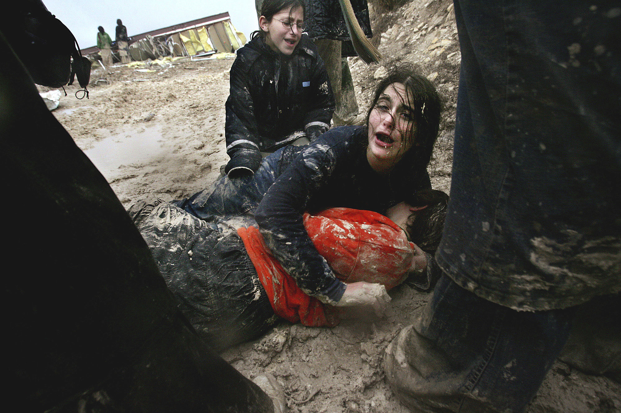 FILE - Israeli settler girls cry in the mud after being dragged away by Israeli army soldiers dismantling an illegal structure at an outpost outside the Jewish settlement of Yitzhar, near the West Bank town of Nablus, Jan. 3, 2005. (AP Photo/Kevin Frayer, File)