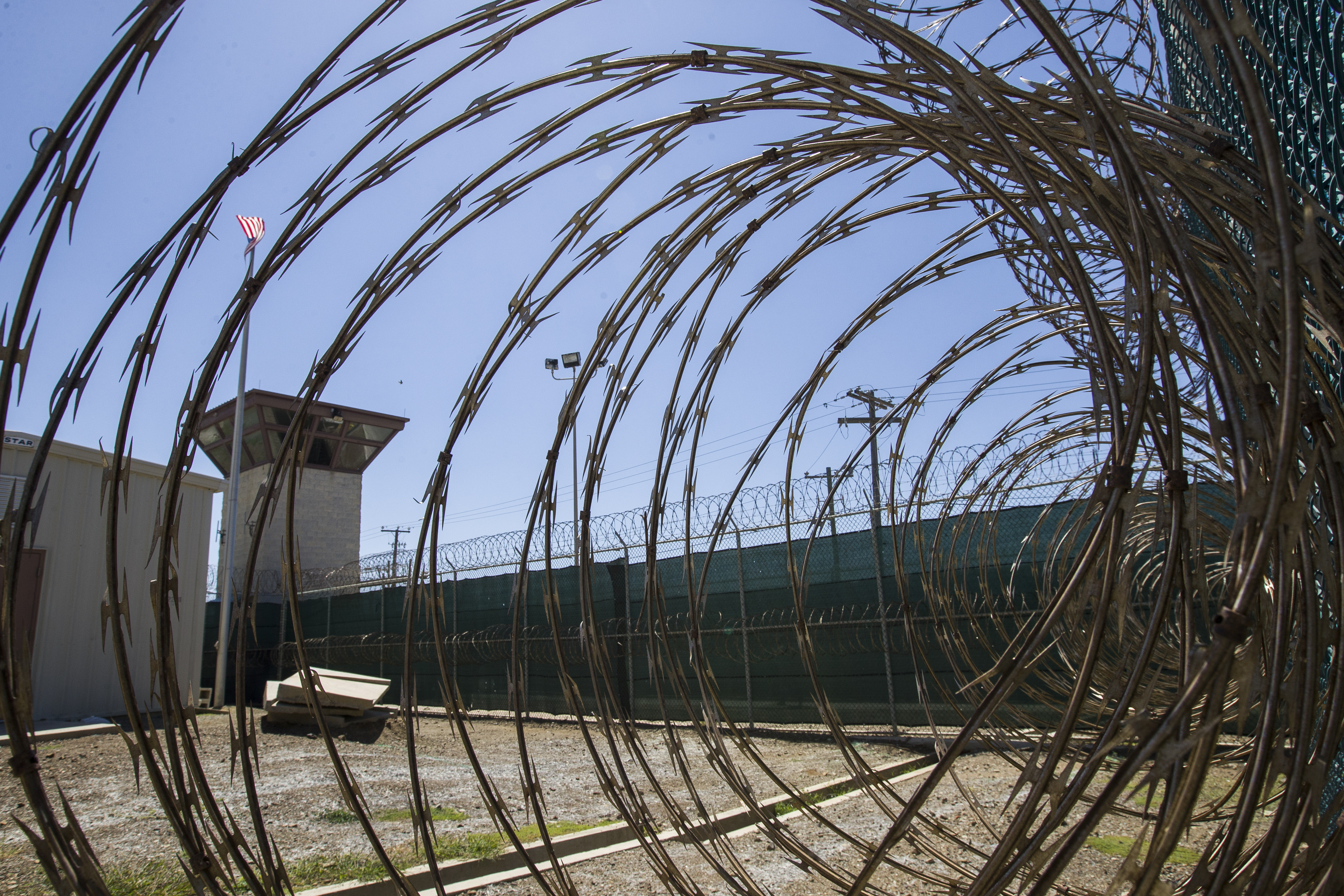 FILE - In this April 17, 2019, photo, reviewed by U.S. military officials, the control tower is seen through the razor wire inside the Camp VI detention facility in Guantanamo Bay Naval Base, Cuba. The U.S. has repatriated a Kenya man held for 17 years without charge at the U.S. military prison in Guantanamo Bay, Cuba. The move leaves 15 other men still waiting for release from Guantanamo after being cleared of wrongdoing after long detentions. (AP Photo/Alex Brandon, File)