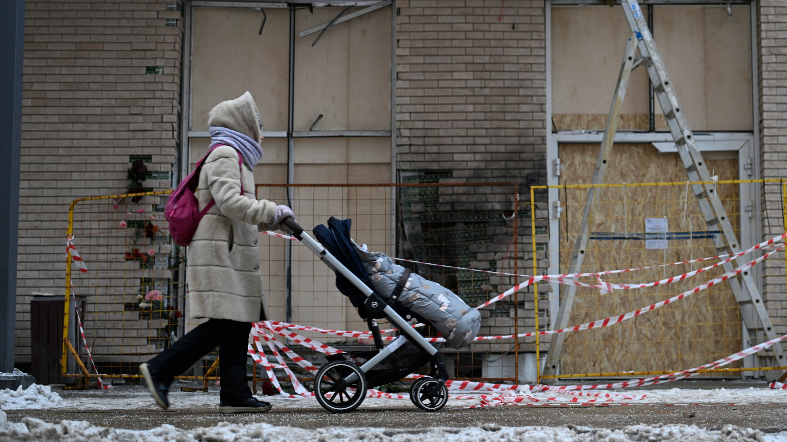 A person walks past an apartment block in Moscow, Russia, Wednesday, Dec. 18, 2024, where a bomb killed Lt. Gen. Igor Kirillov, head of Russia's Radiation, Biological and Chemical Defense Forces and his assistant, Ilya Polikarpov. (AP Photo/Dmitry Serebryakov)