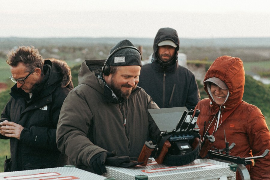 This image released by A24 shows filmmaker Brady Corbet, center, appears on the set of "The Brutalist." (A24 via AP)