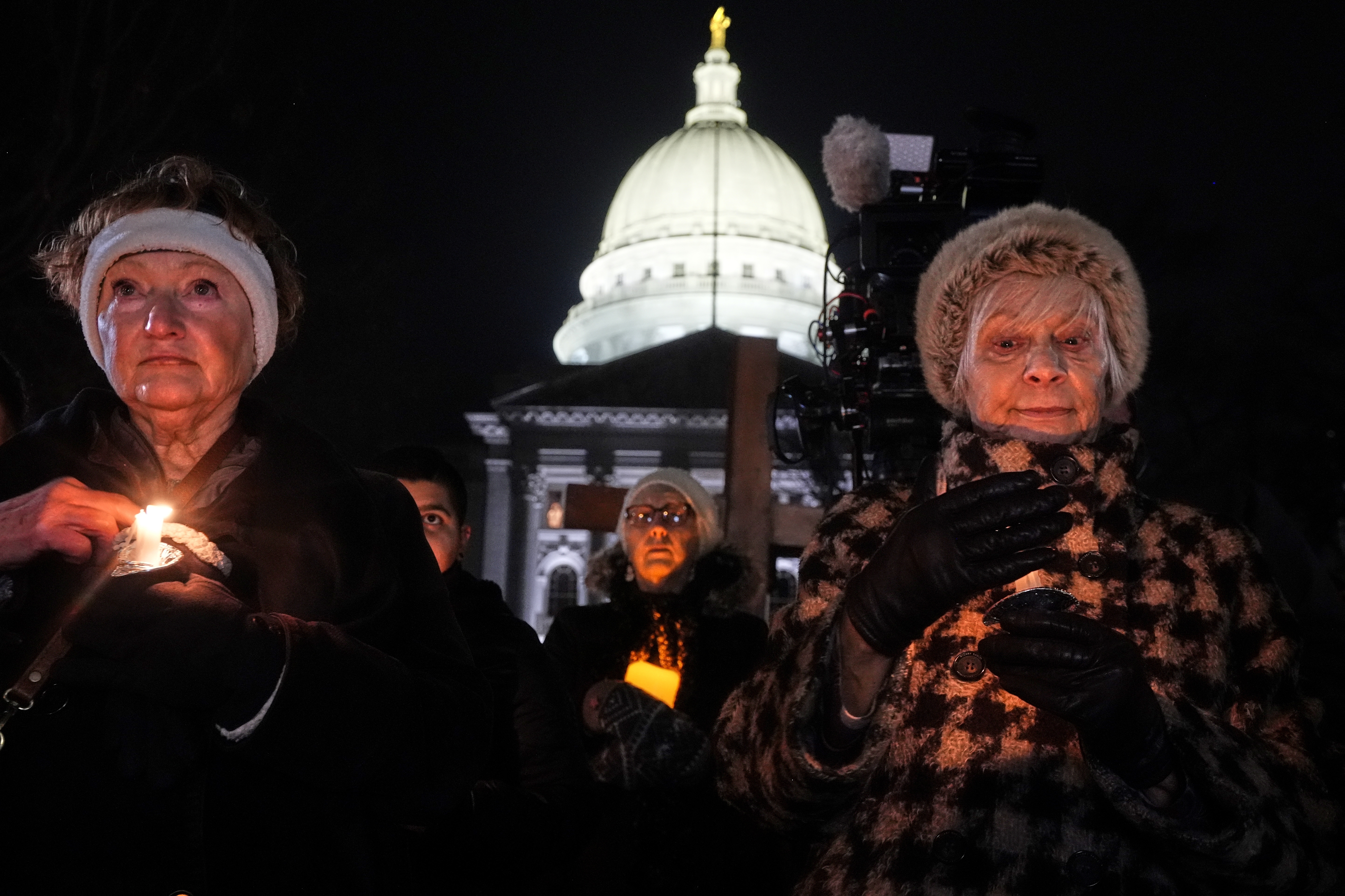 Supporters hold candles during a candlelight vigil Tuesday, Dec. 17, 2024, outside the Wisconsin Capitol in Madison, Wis., following a shooting at the Abundant Life Christian School on Monday, Dec. 16. (AP Photo/Morry Gash)