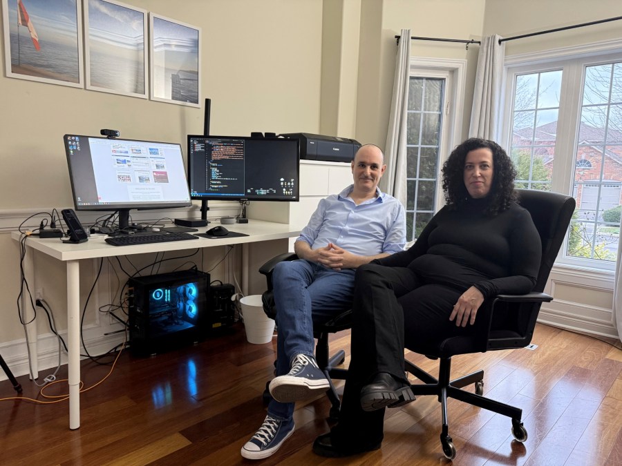 Michal Harel and her husband Avital Epstein show the website they set up to help Israelis navigate a move to Canada in Oakville, Ontario, Canada, Wednesday, Dec. 4, 2024. (AP Photo/Rob Gillies)