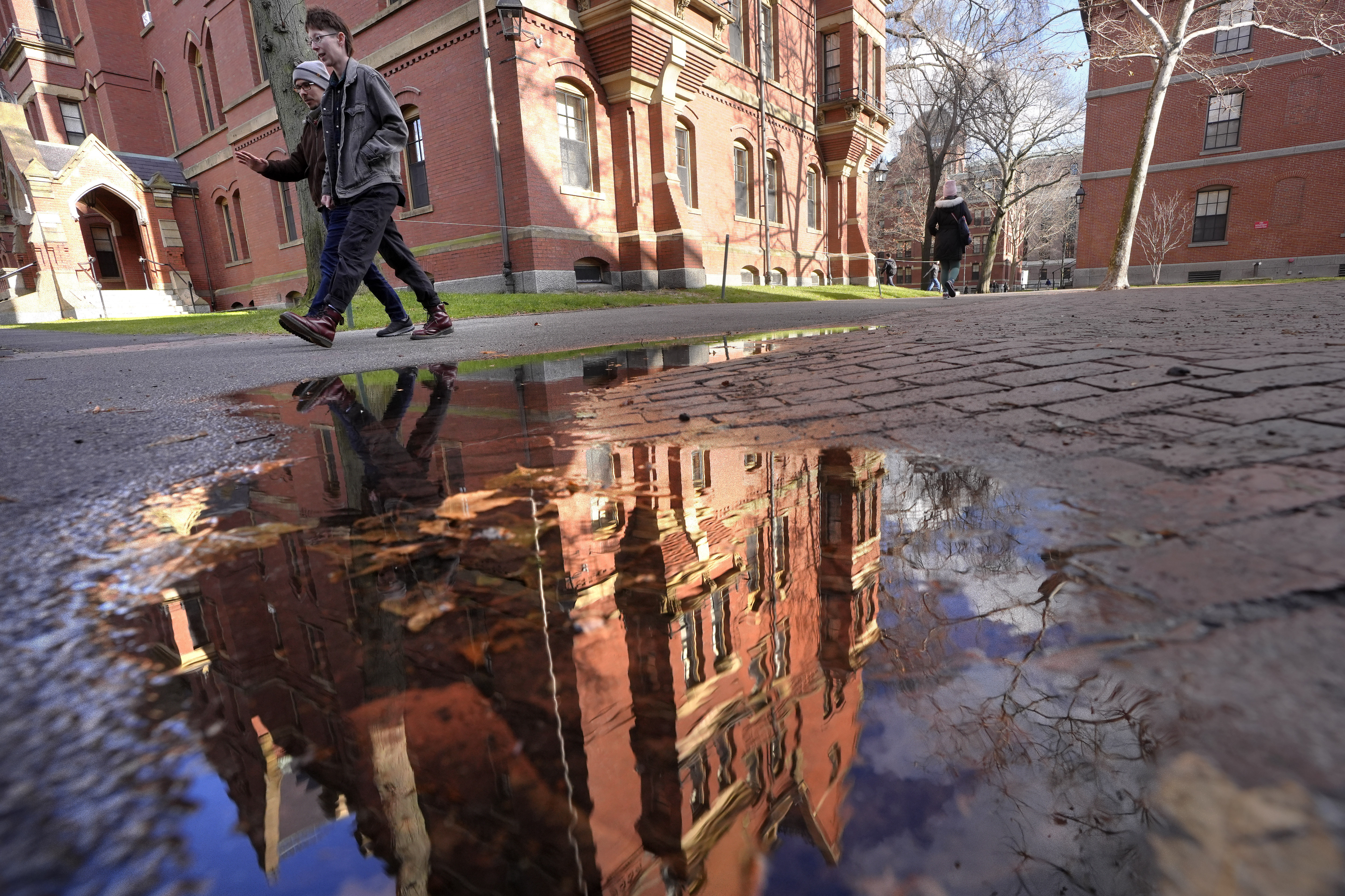 People walk between buildings, Tuesday, Dec. 17, 2024, on the campus of Harvard University in Cambridge, Mass. (AP Photo/Steven Senne)