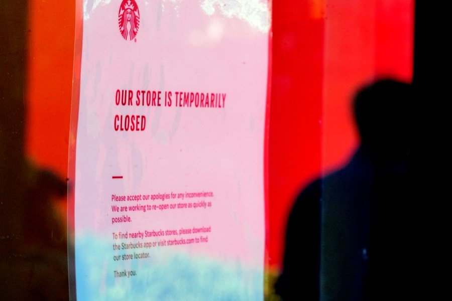 A closed store sign is seen in the window of a Starbucks as workers picket outside the location on company Friday, Dec. 20, 2024, in Burbank, Calif. (AP Photo/Damian Dovarganes)