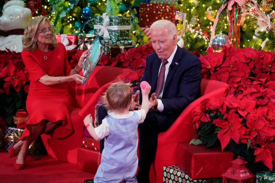 President Joe Biden and first lady Jill Biden, as she reads 'Twas the Night Before Christmas, visit patients and families at the Children's National Hospital in Washington, Friday, Dec. 20, 2024. (AP Photo/Ben Curtis)