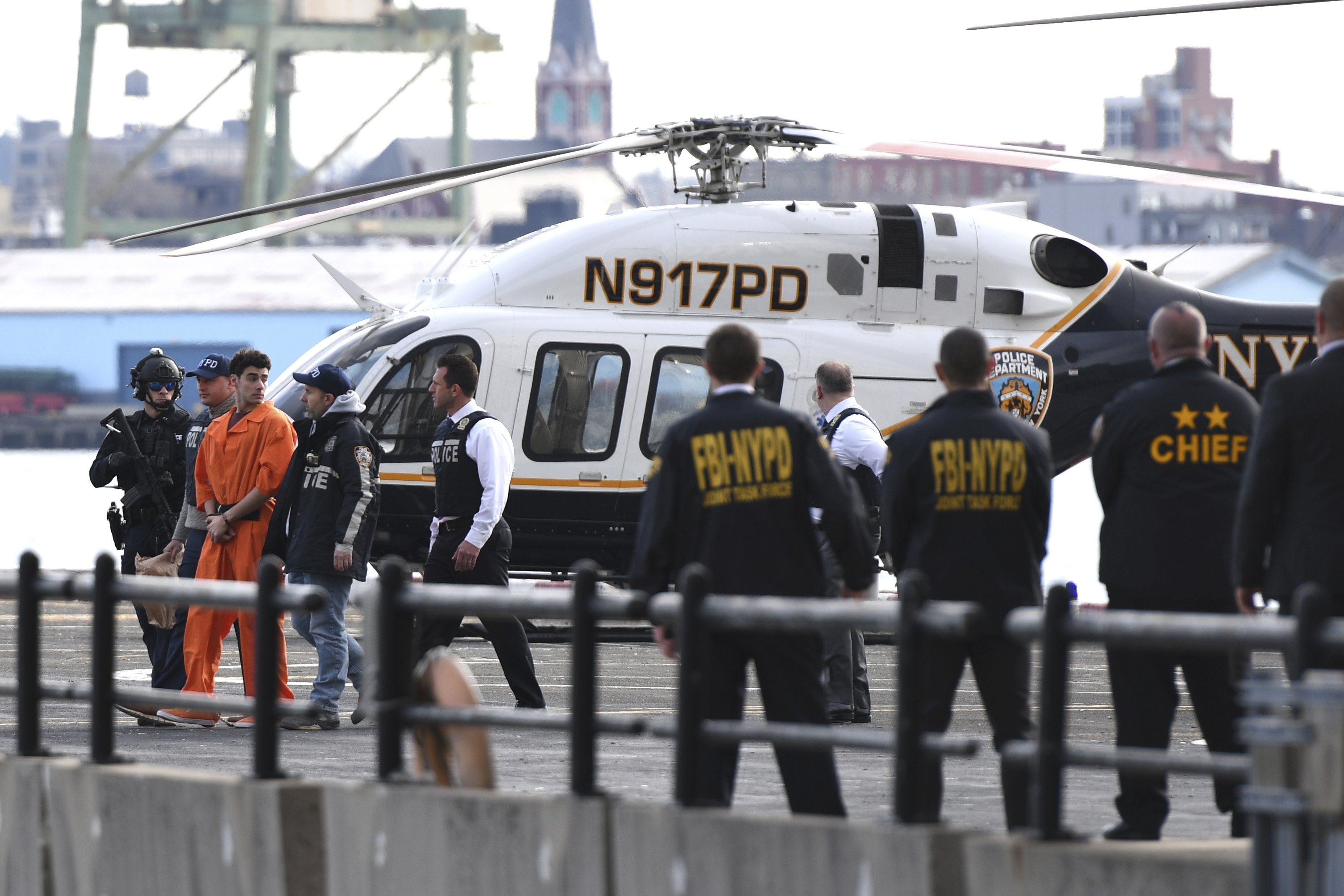 Luigi Mangione, a suspect in the fatal shooting of UnitedHealthcare CEO Brian Thompson, is escorted off of a helicopter by police, Thursday, Dec. 19, 2024, in New York. (AP Photo/Pamela Smith)