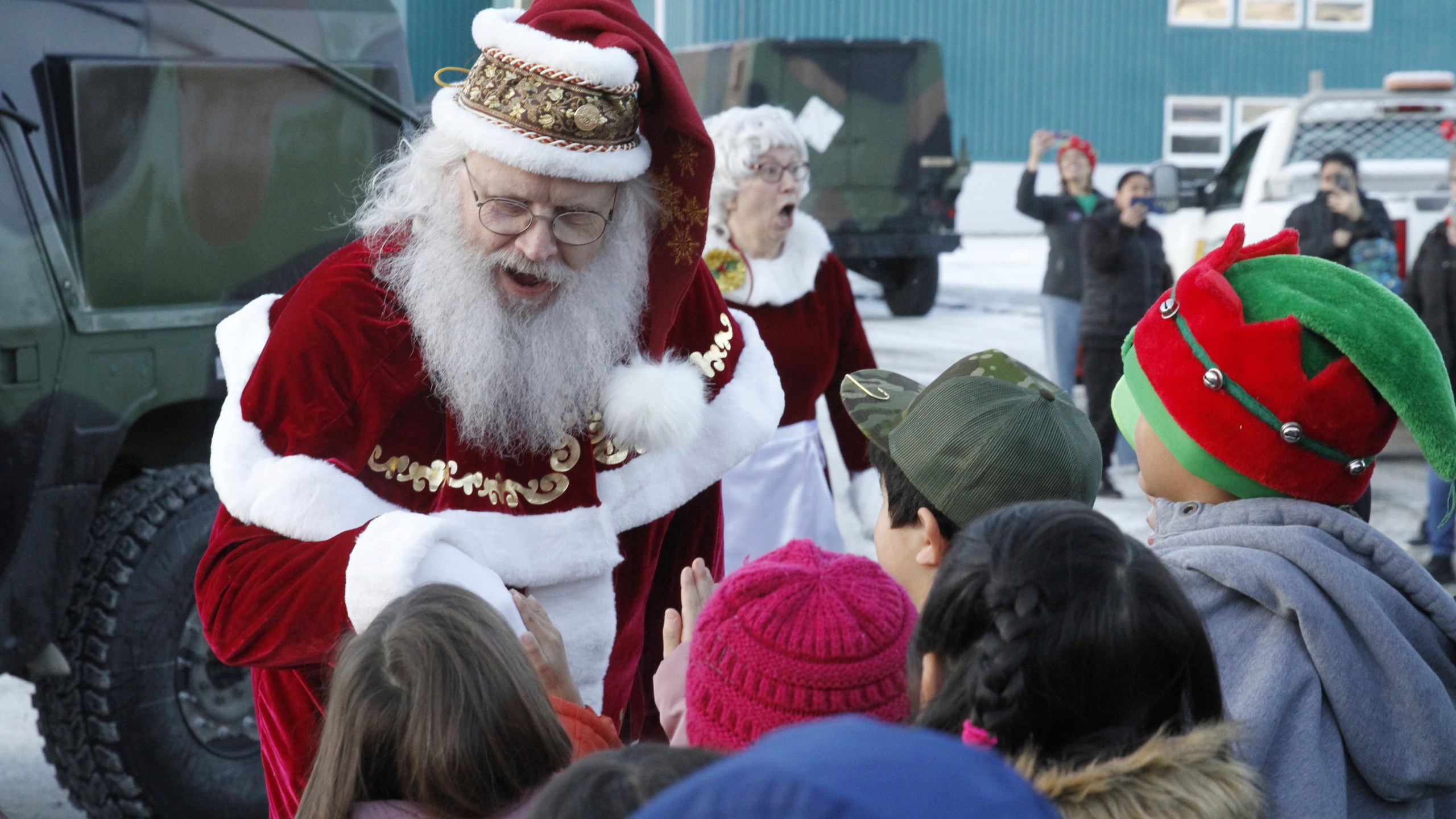 Santa Claus meets children after arriving at the school in Yakutat, Alaska, as part of the Alaska National Guard's Operation Santa initiative that brings Christmas to an Indigenous community that has suffered a hardship, Wednesday, Dec. 18, 2024. (AP Photo/Mark Thiessen).