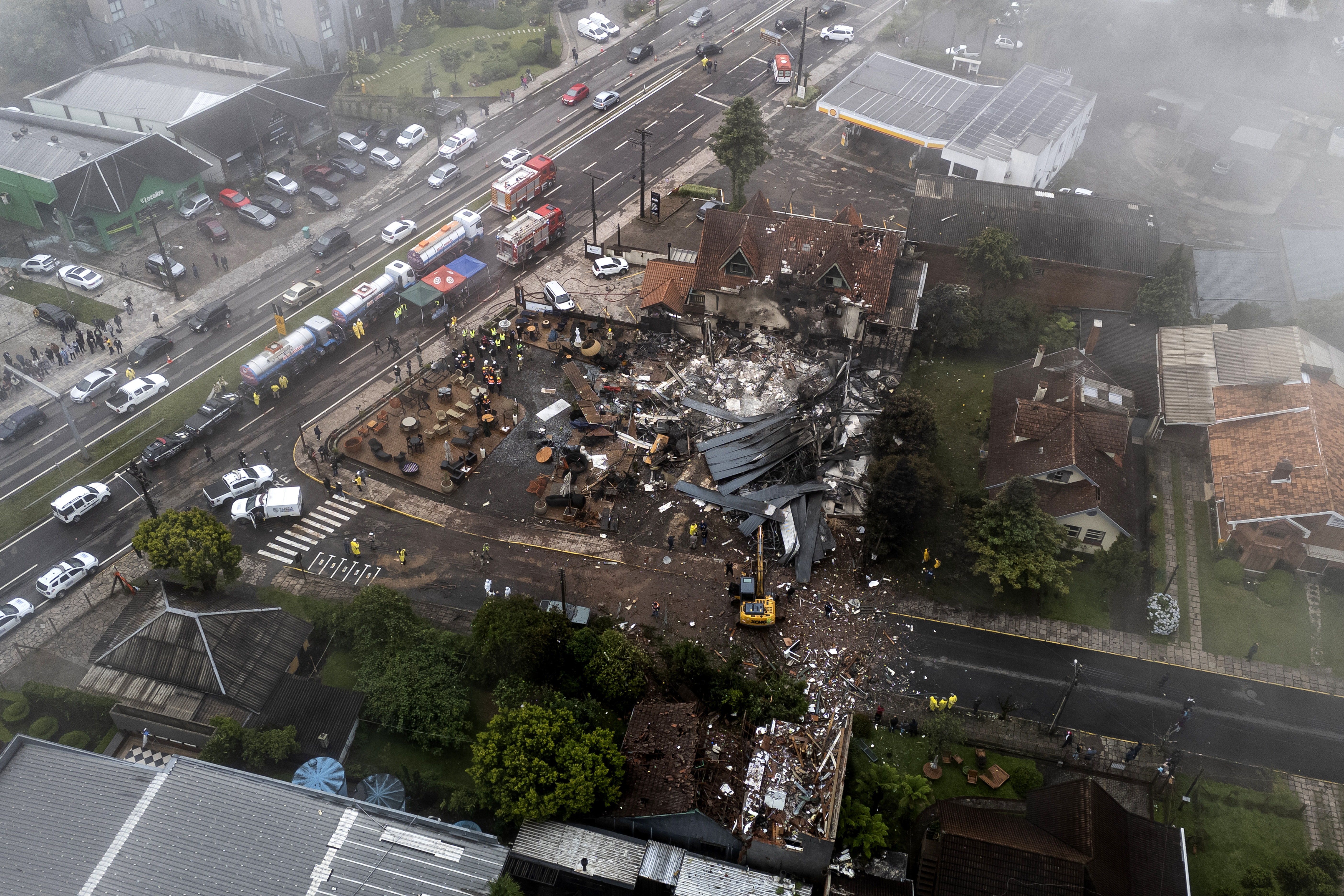 Police carry out an investigation by houses that were hit by a plane in Gramado, Rio Grande do Sul state, Brazil, Sunday, Dec. 22, 2024. (AP Photo/Mateus Bruxel, Agência RBS)