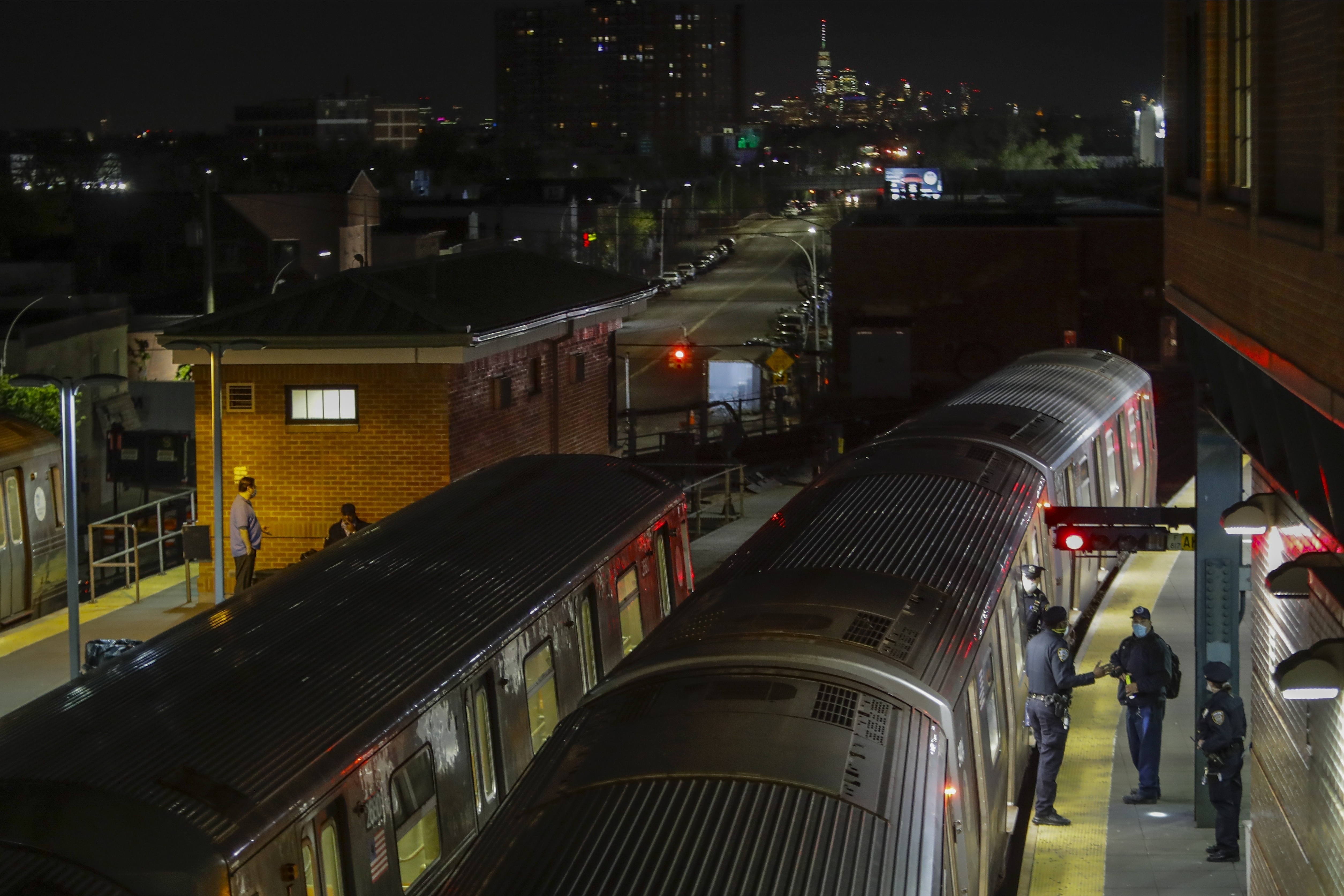 FILE - New York Police officers clear a train at the Coney Island Stillwell Avenue Terminal, May 5, 2020, in the Brooklyn borough of New York. (AP Photo/Frank Franklin II, file)