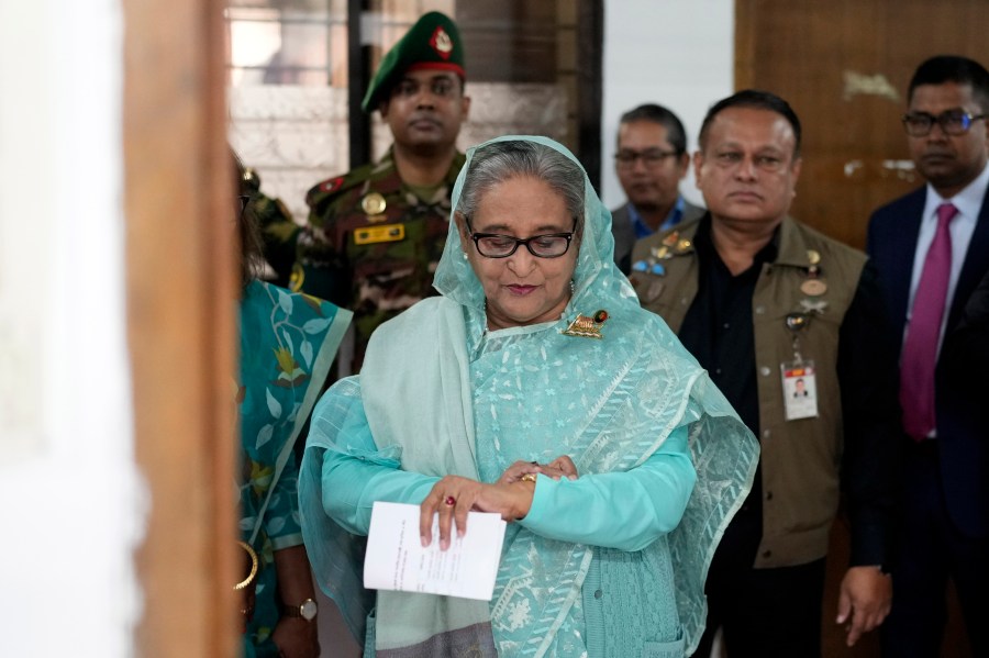 Bangladesh Prime Minister Sheikh Hasina checks her watch as she waits for the official opening time to cast her vote in Dhaka, Bangladesh, Jan. 7, 2024. (AP Photo/Altaf Qadri)