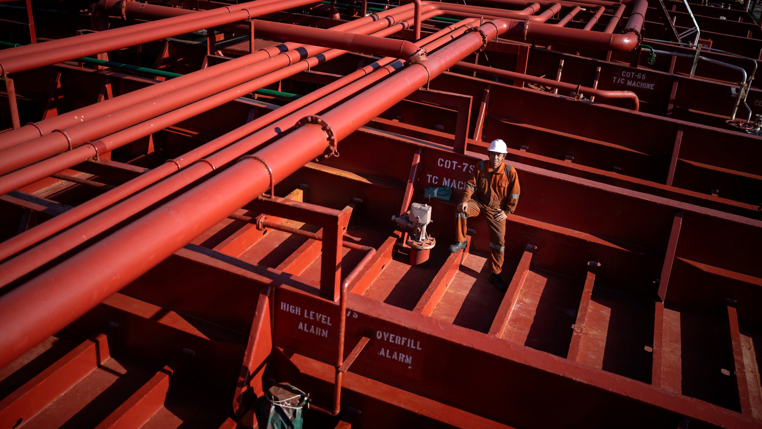 Rahil Gunawan, 55, of Indonesia, poses on the deck of the chemical tanker on which he works as a deckhand while calling at the port of Barcelona, Spain, Friday, Sept. 27, 2024. Gunawan, who has five children and has been working on cargo ships for more than 25 years, spends seven to ten months at sea per year. (AP Photo/Emilio Morenatti)