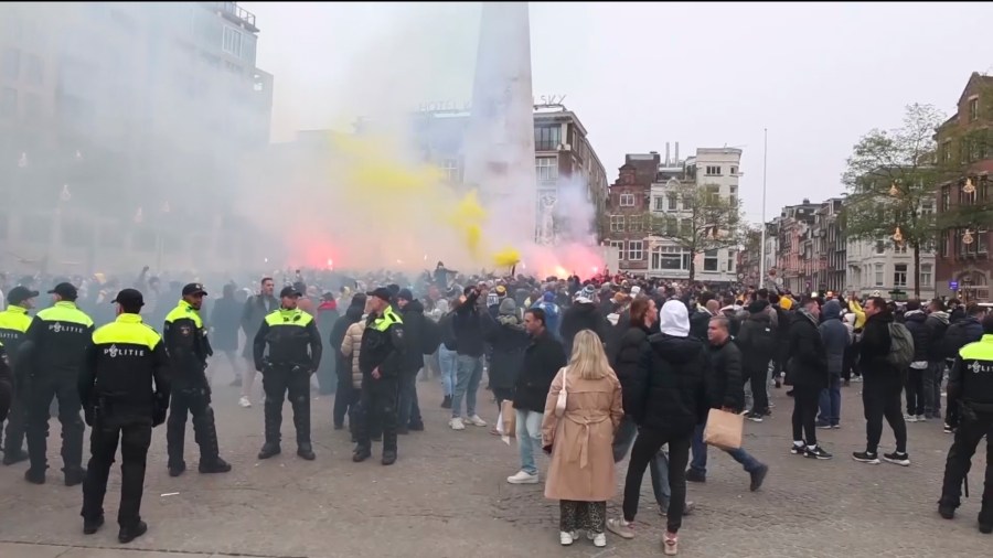 FILE - In this image taken from video, police stand guard as Maccabi Tel Aviv supporters light flares at the Dam square, in Amsterdam, the Netherlands, Thursday, Nov. 7, 2024. (AP Photo InterVision, File)