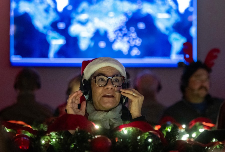 Volunteers answer phone calls from around the world Tuesday, Dec. 24, 2024, at the NORAD Tracks Santa center at Peterson Space Force Base in Colorado Springs, Colo. (Christian Murdock /The Gazette via AP)