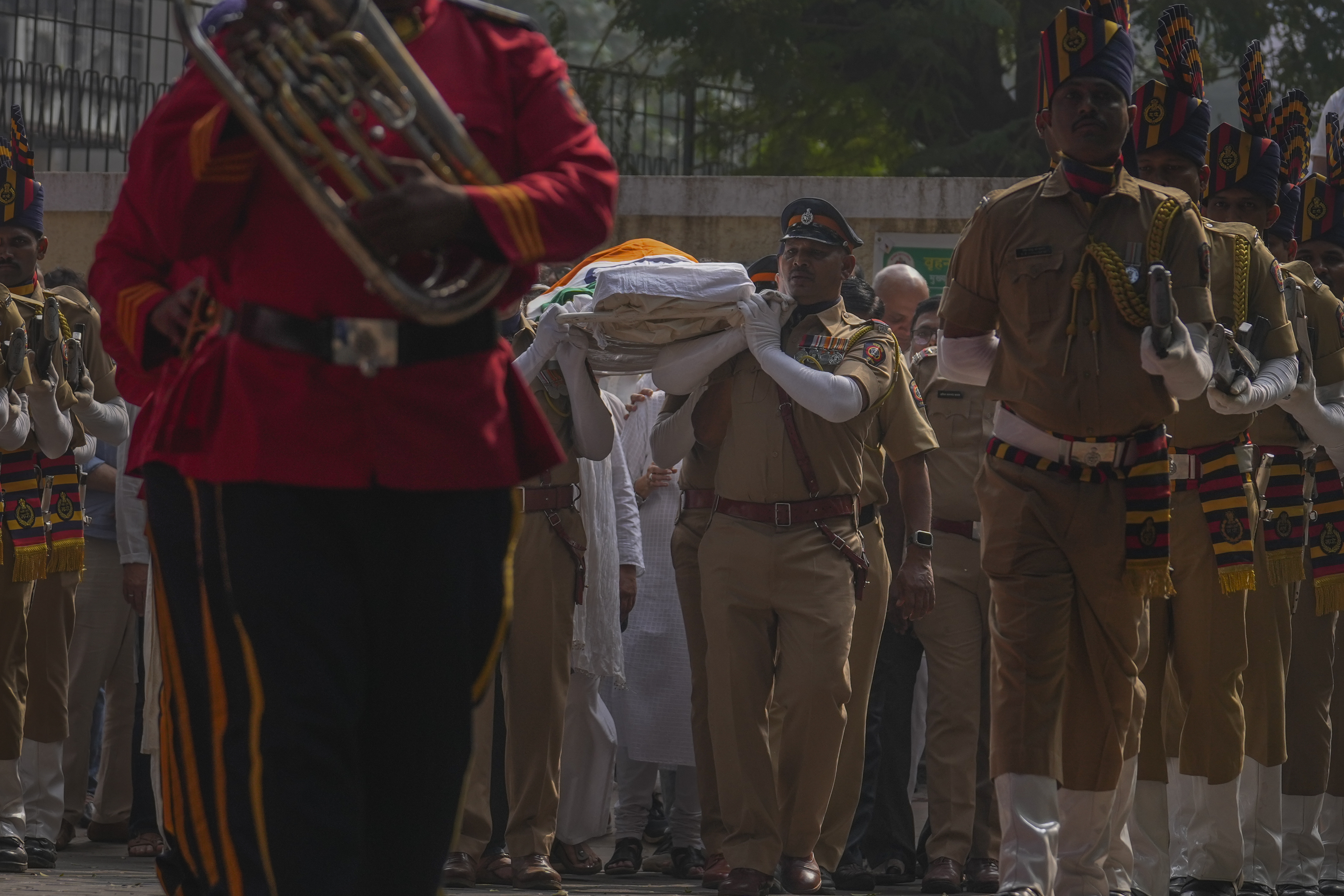 Police officers carry the body of Shyam Benegal, a renowned Indian filmmaker who passed away on Monday, during Benegal's funeral in Mumbai, India, Tuesday, Dec. 24, 2024. (AP Photo/Rafiq Maqbool)