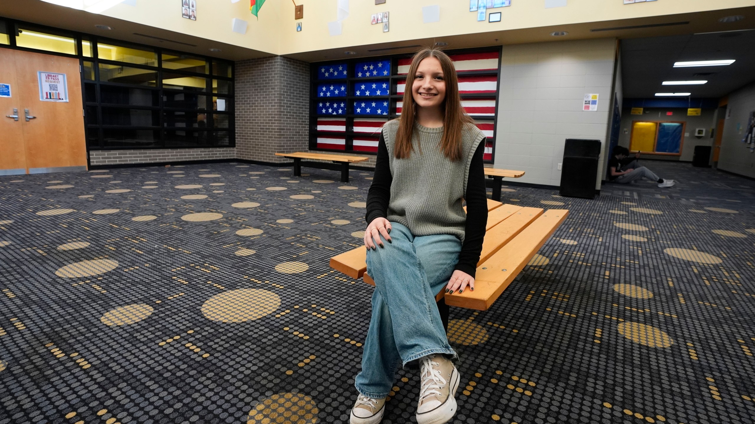 Makenzie Gilkison sits in the lobby at Greenfield Central High School, Tuesday, Dec. 17, 2024, in Greenfield, Ind. (AP Photo/Darron Cummings)