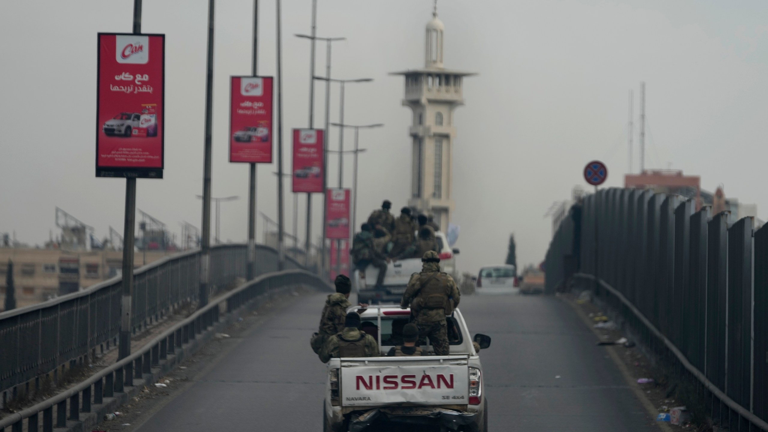 Syrian fighters travel on vehicles, as they patrol at a highway, in Damascus, Syria, Thursday, Dec. 26, 2024. (AP Photo/Hussein Malla)