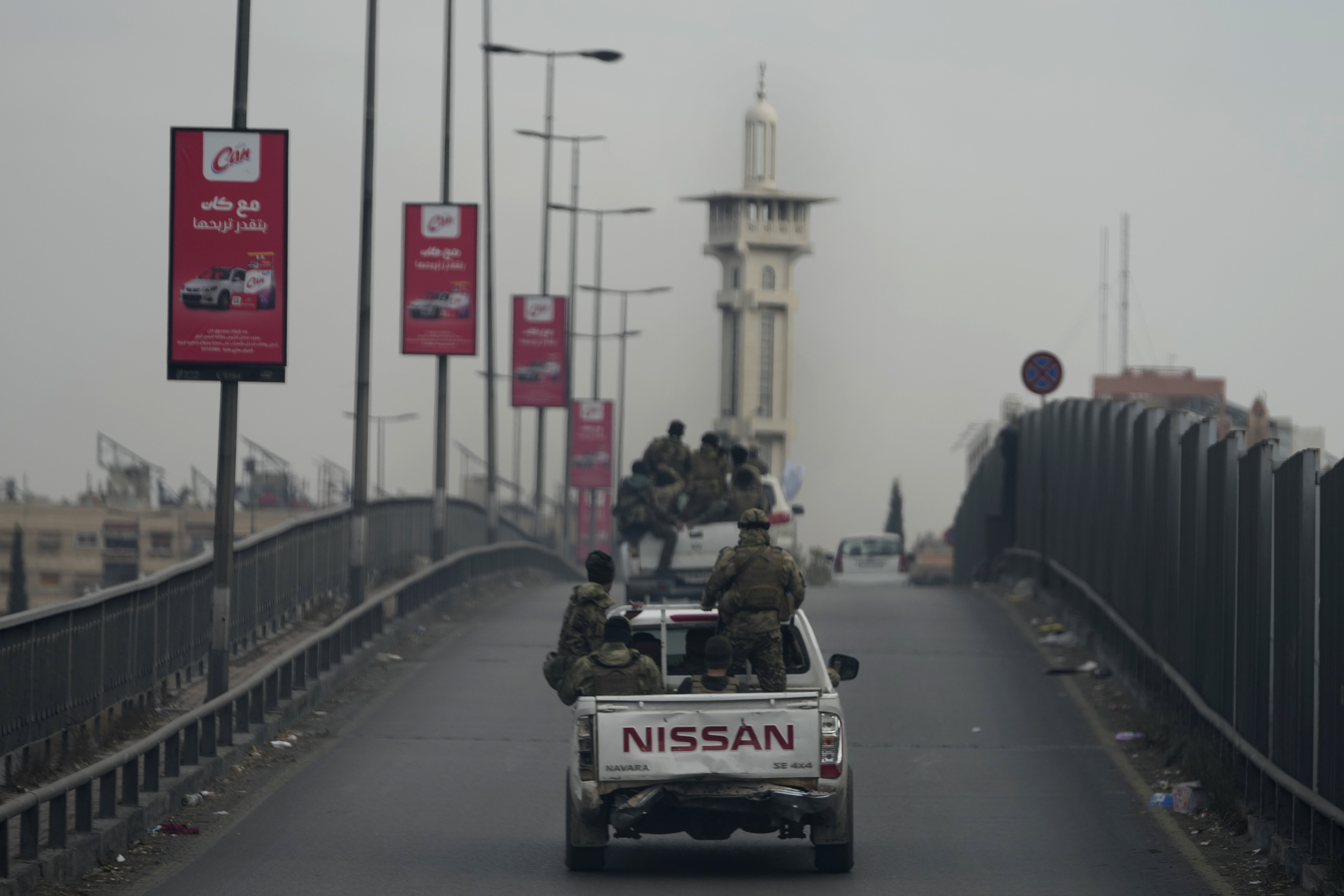 Syrian fighters travel on vehicles, as they patrol at a highway, in Damascus, Syria, Thursday, Dec. 26, 2024. (AP Photo/Hussein Malla)