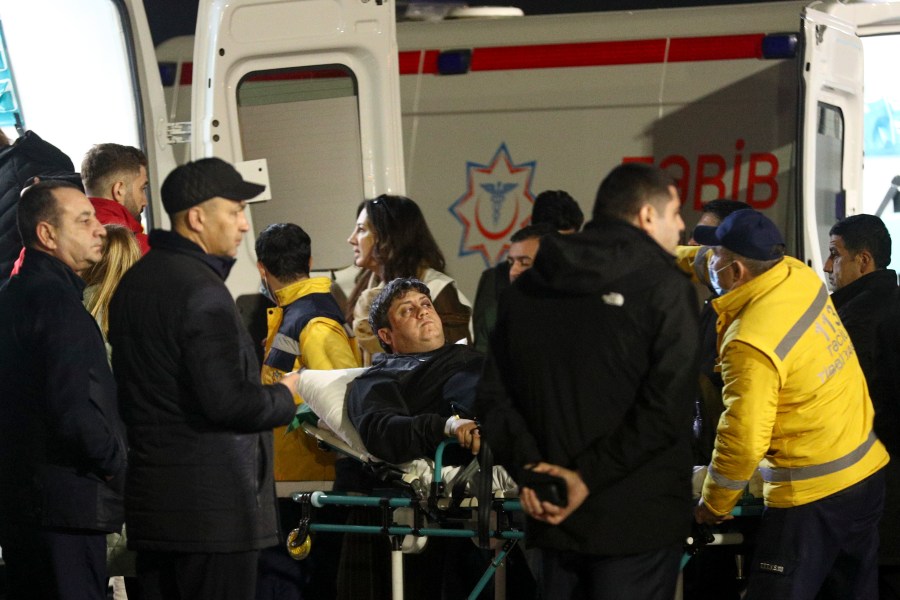 Rescuers transport wounded passengers from a medical plane after the Azerbaijani Airline crashed, near the Kazakhstani city of Aktau, upon their arrival at the Heydar Aliyev International Airport outside Baku, Azerbaijan, Thursday, Dec. 26, 2024. (AP Photo)