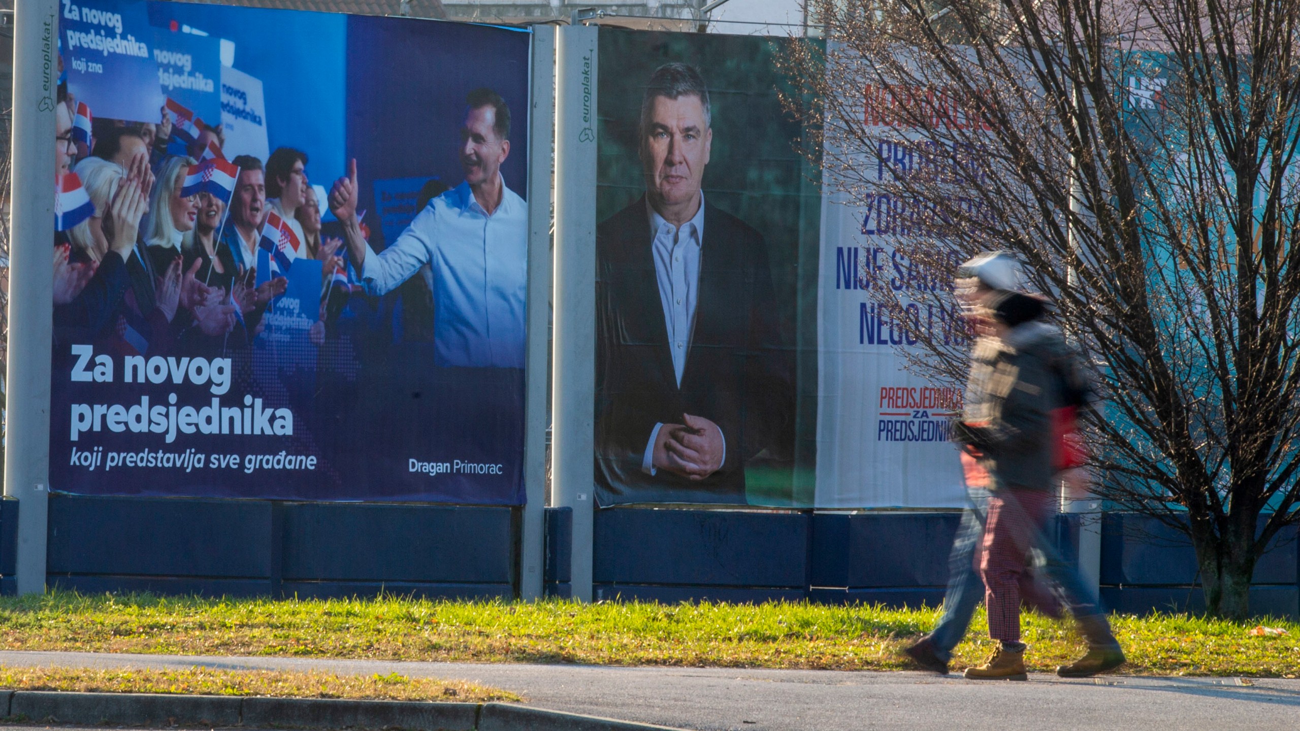 Pedestrians walk past campaign posters of presidential candidates Dragan Primorac and Zoran Milanovic ahead of the presidential election in Zagreb, Croatia, Thursday, Dec. 26, 2024. (AP Photo)