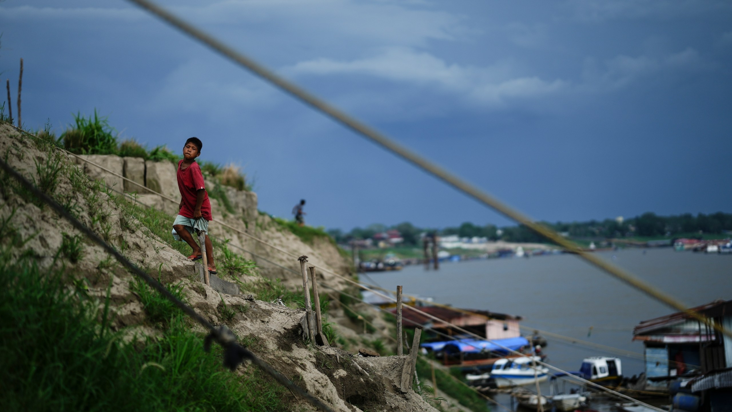 FILE - A boy climbs a hill near a low Amazon River due to the drought, in Leticia, Colombia, Oct. 20, 2024. (AP Photo/Ivan Valencia, File)