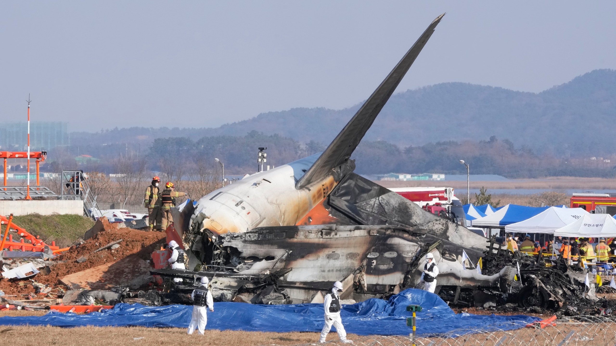 Firefighters and rescue team members work near the wreckage of a passenger plane at Muan International Airport in Muan, South Korea, Sunday, Dec. 29, 2024. (AP Photo/Ahn Young-joon)