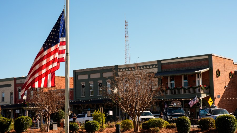 A flag flies at half-staff on main street in the aftermath of former President Jimmy Carter's death, Monday, Dec. 30, 2024, in Plains, Ga. Carter died Sunday at the age of 100.(AP Photo/Mike Stewart)