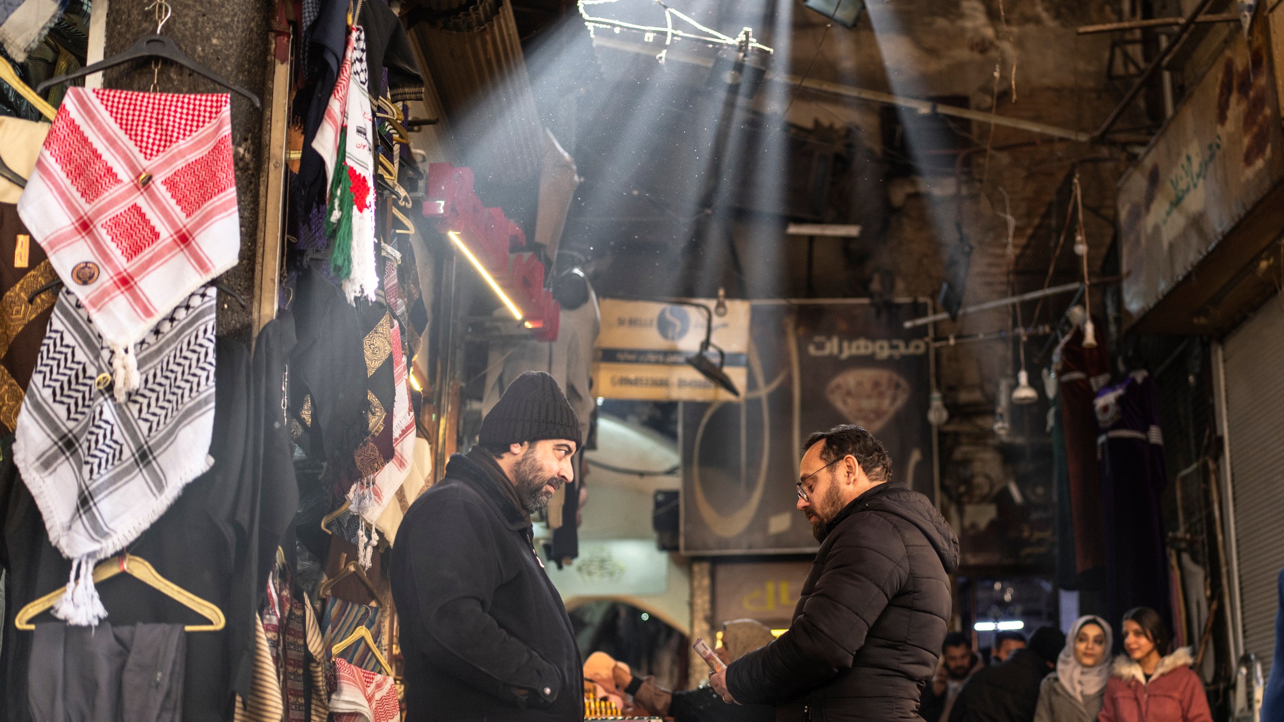 Shop owners talk while they wait for clients in Al-Hamidiyeh Souq on New Years Eve, in Damascus, Syria, Tuesday, Dec. 31, 2024. (AP Photo/Mosa'ab Elshamy)