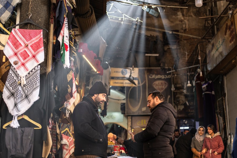 Shop owners talk while they wait for clients in Al-Hamidiyeh Souq on New Years Eve, in Damascus, Syria, Tuesday, Dec. 31, 2024. (AP Photo/Mosa'ab Elshamy)