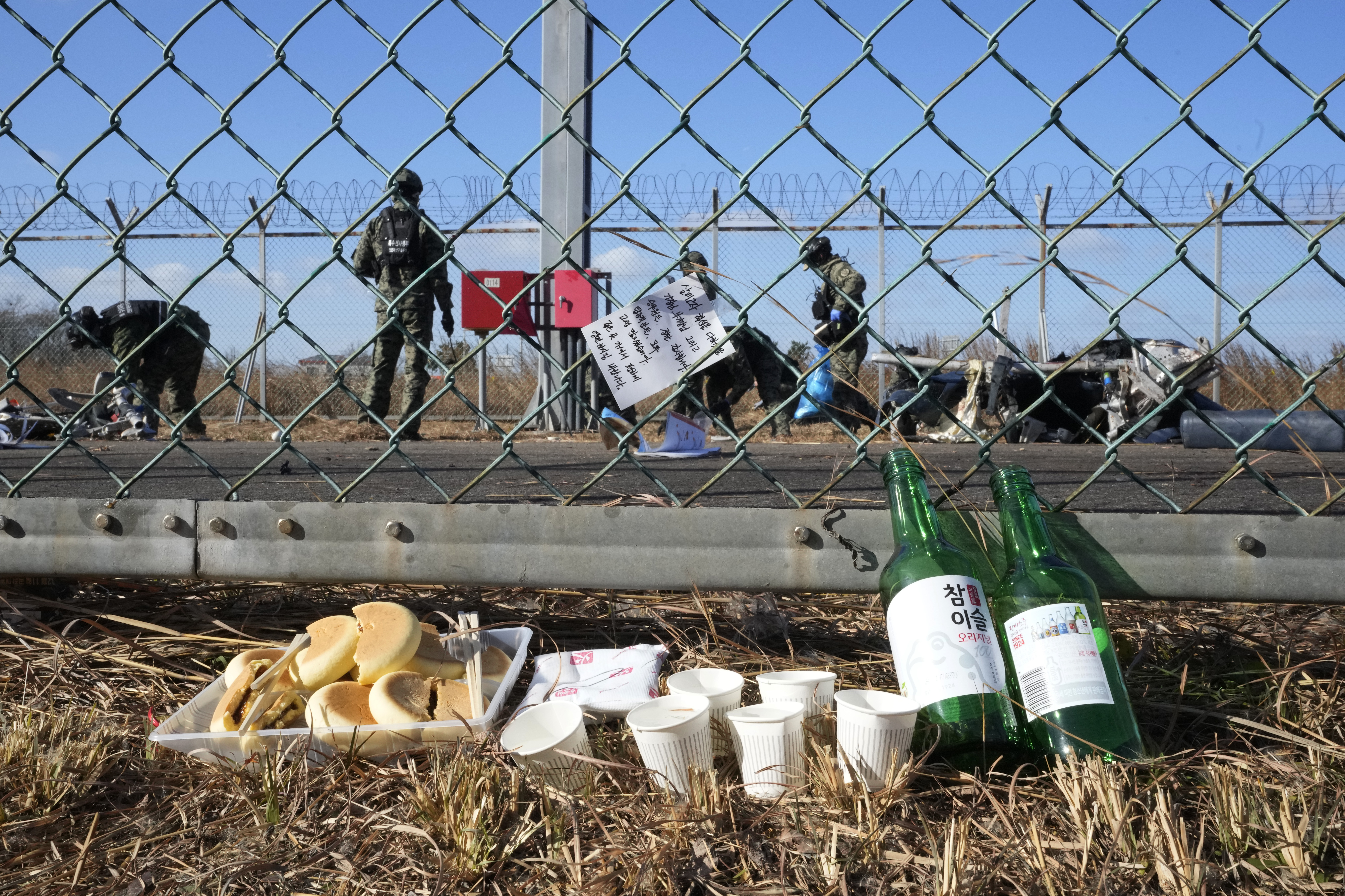 A message of condolences and foods are seen outside of Muan International Airport in Muan, South Korea, Tuesday, Dec. 31, 2024, following Sunday's plane crash. (AP Photo/Ahn Young-joon)