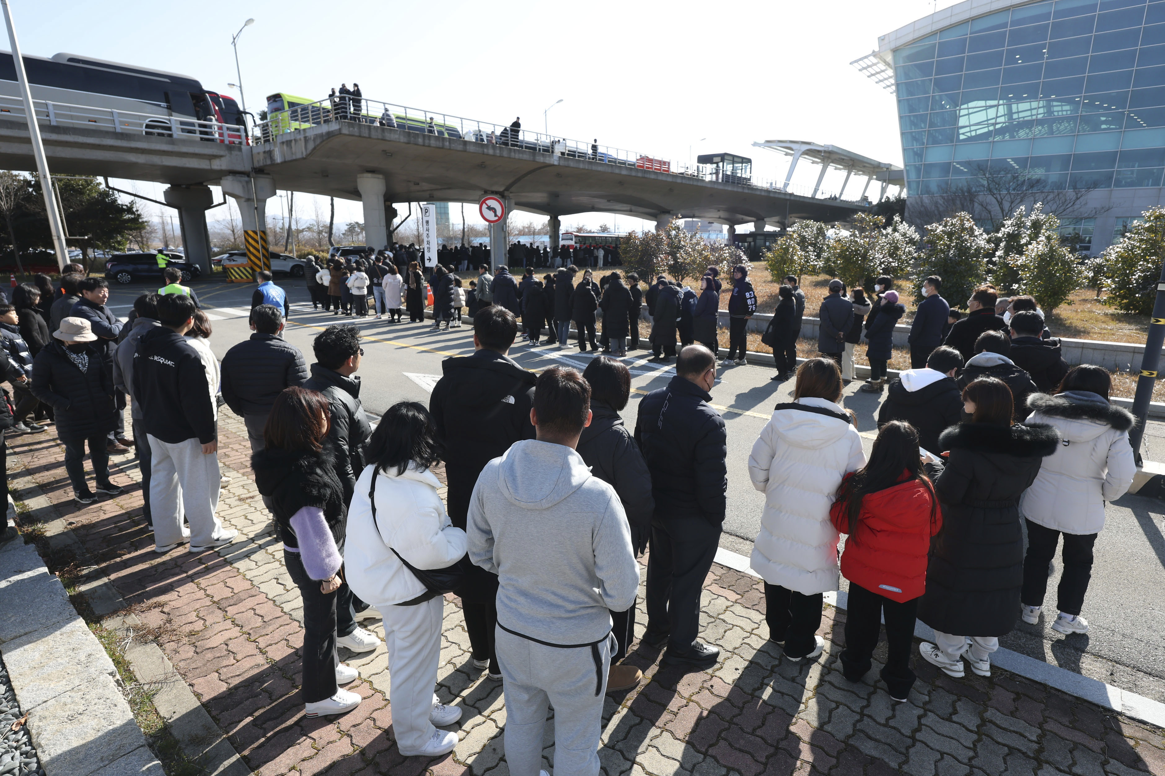 Mourners wait to pay tribute to the victims of a plane fire at a memorial altar at Muan International Airport in Muan, South Korea, Wednesday, Jan. 1, 2025. (Kim Sun-woong/Newsis via AP)