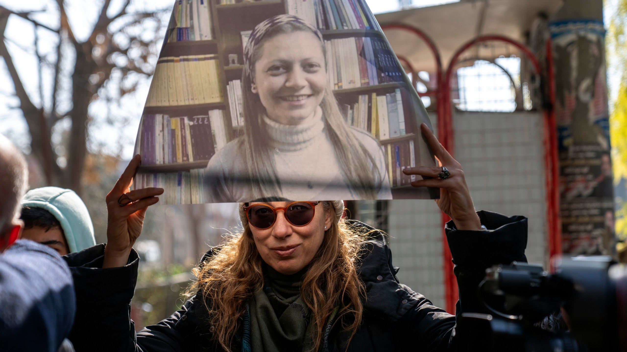 A woman holds a portrait of Razan Zaitouneh who disappeared during the war between opposition groups and former President Bashar Assad's forces, during a protest in Douma, Syria, Wednesday, Jan. 1, 2025. (AP Photo/Mosa'ab Elshamy)