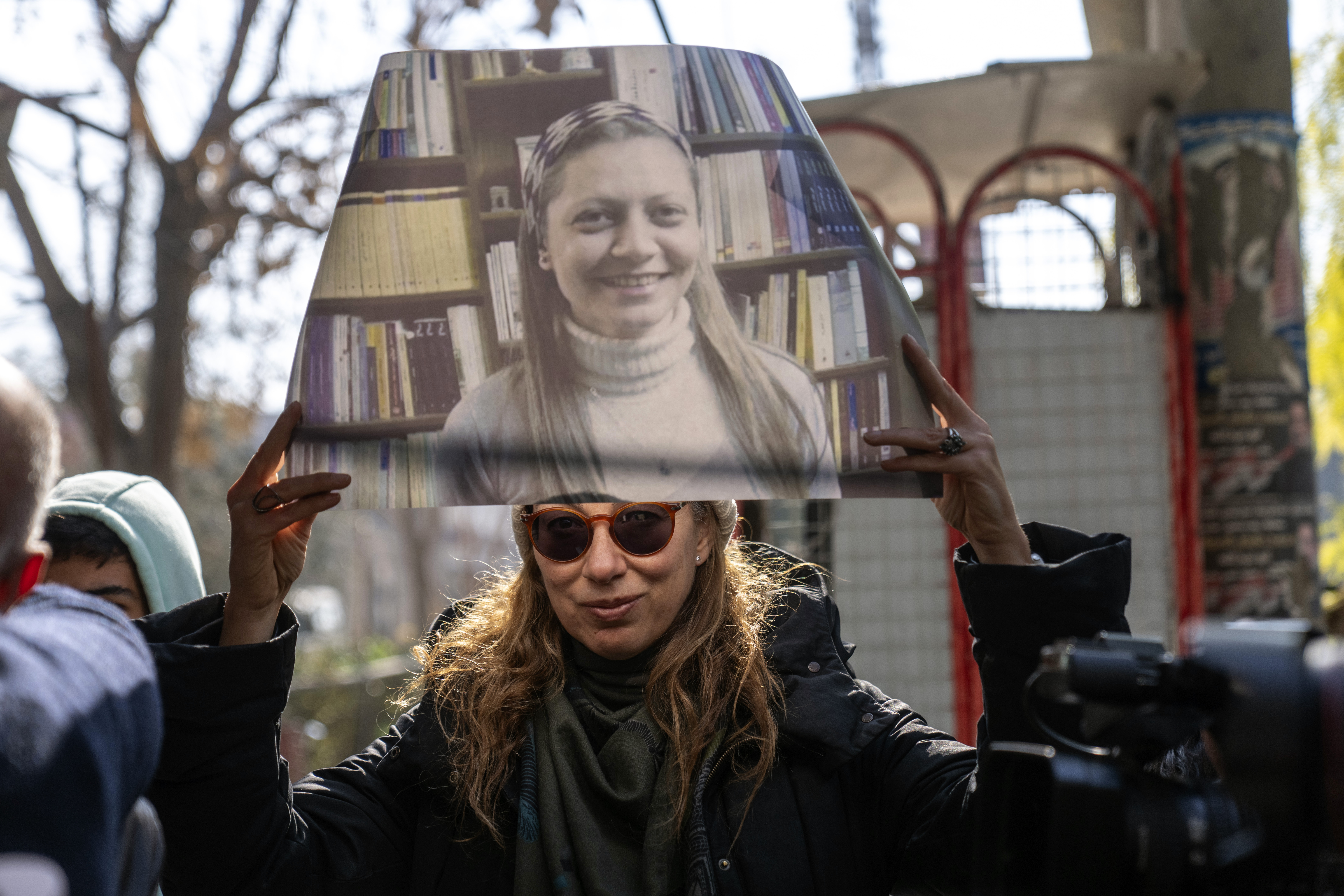 A woman holds a portrait of Razan Zaitouneh who disappeared during the war between opposition groups and former President Bashar Assad's forces, during a protest in Douma, Syria, Wednesday, Jan. 1, 2025. (AP Photo/Mosa'ab Elshamy)