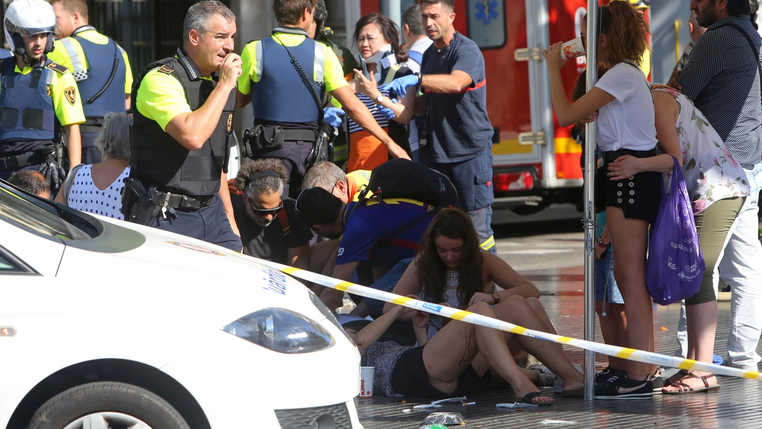 FILE - Injured people are treated in Barcelona, Spain, Thursday, Aug. 17, 2017 after a white van jumped the sidewalk in the historic Las Ramblas district, crashing into a summer crowd of residents and tourists. (AP Photo/Oriol Duran, File)