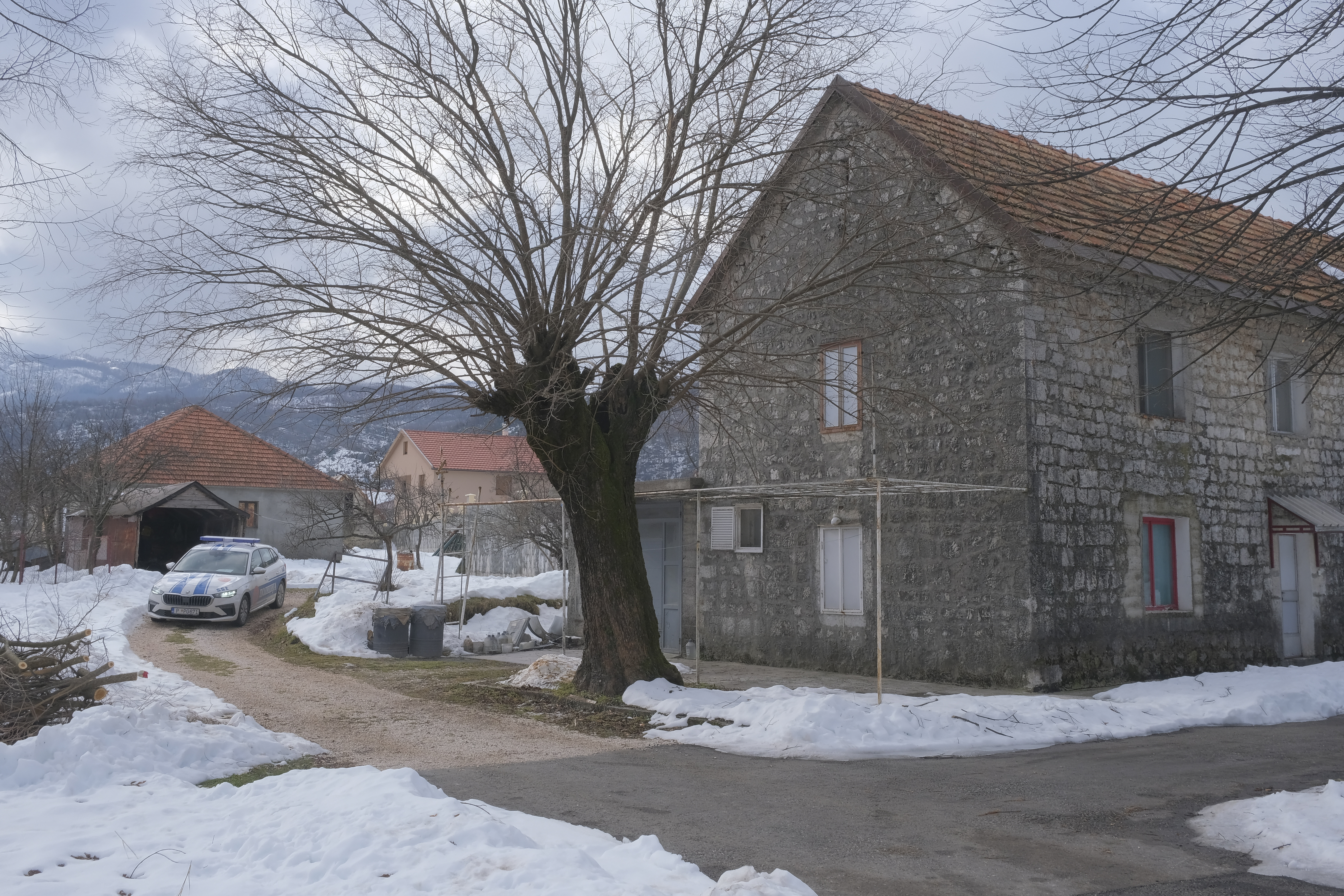 A view of a police vehicle at the home of a gunman after a shooting incident, in Cetinje, 36 kilometers (22 miles) west of Podogrica, Montenegro, Thursday, Jan. 2, 2025. (AP Photo/Risto Bozovic)