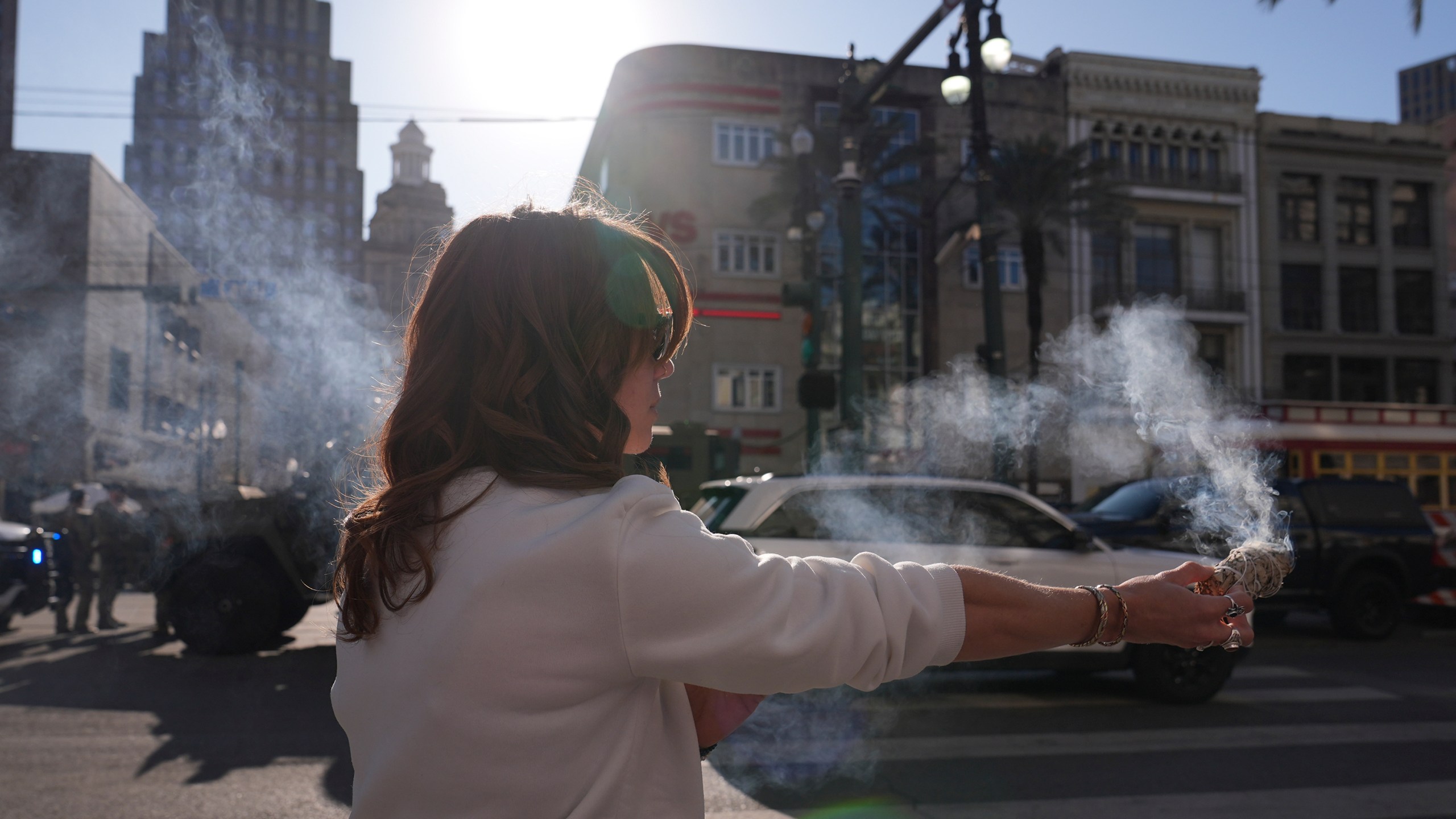 Stephanie Drake burns sage on Canal and Bourbon Street, Thursday, Jan. 2, 2025 in New Orleans. (AP Photo/George Walker IV)