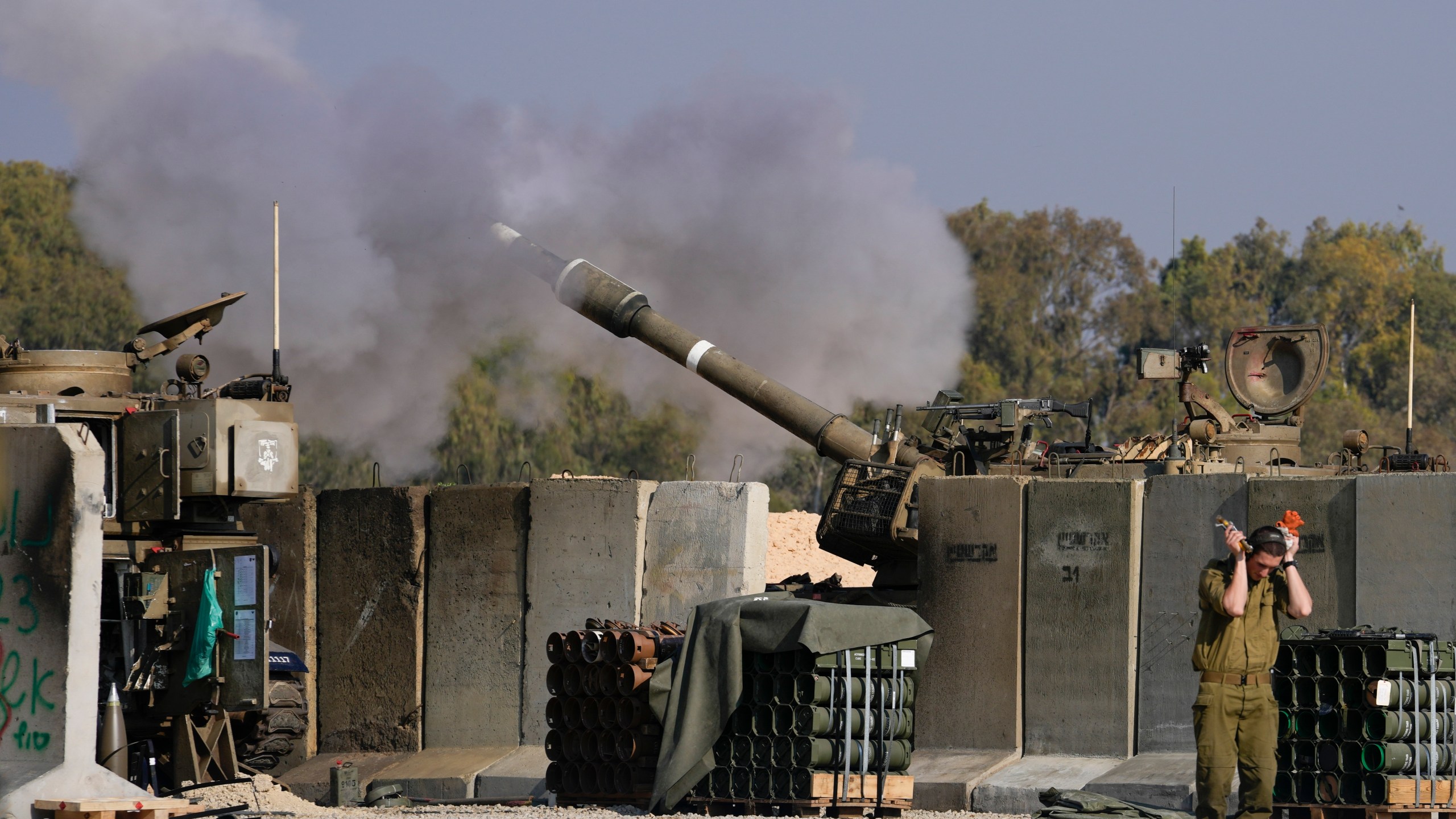 An Israeli soldier covers his ears as an artillery gunner fires into the Gaza Strip from a position in southern Israel, Thursday, Jan. 2, 2025.(AP Photo/Matias Delacroix)