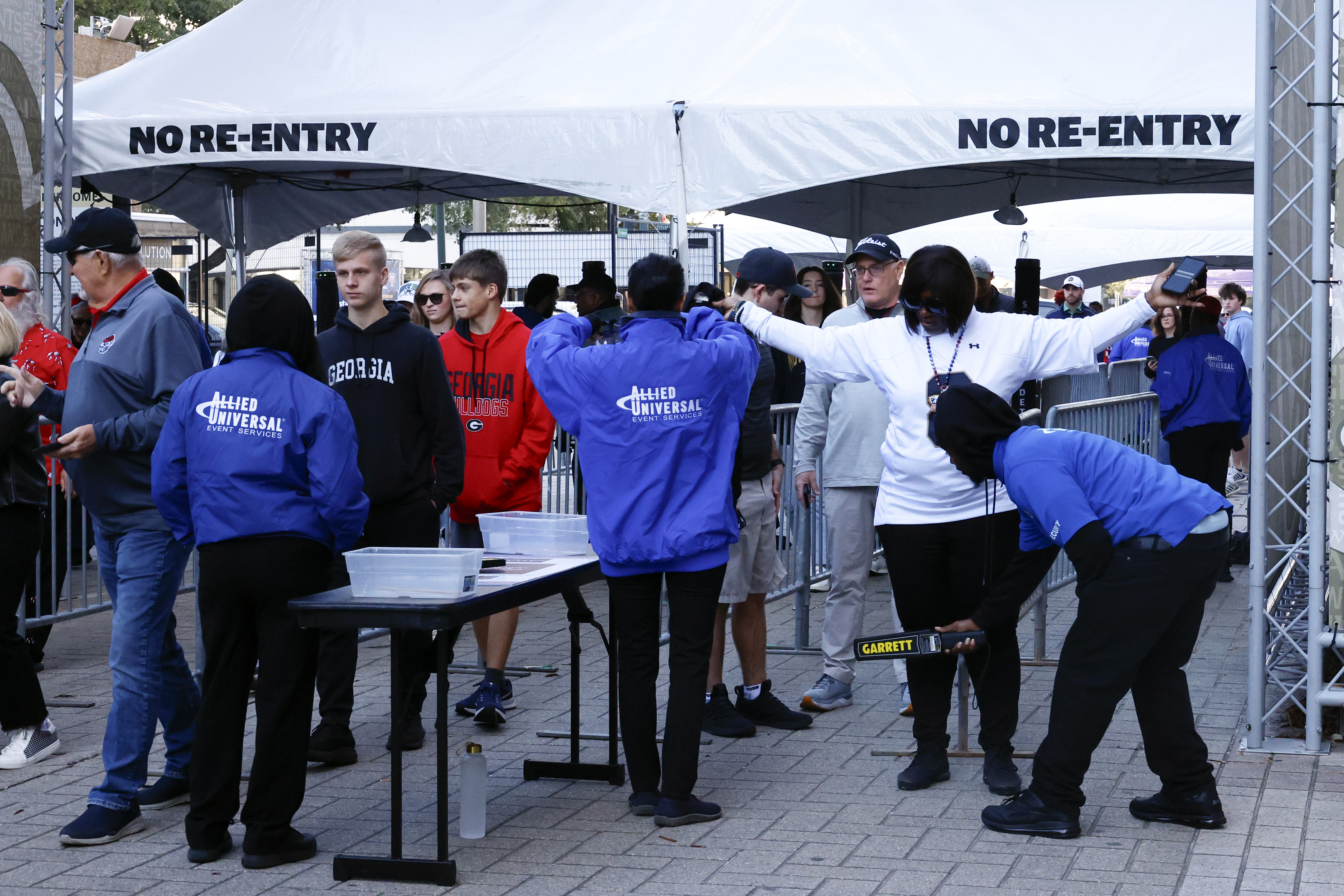 Fans pass through security check points as they enter the Caesars Superdome fan zone ahead of the Sugar Bowl NCAA College Football Playoff game, Thursday, Jan. 2, 2025, in New Orleans. (AP Photo/Butch Dill)