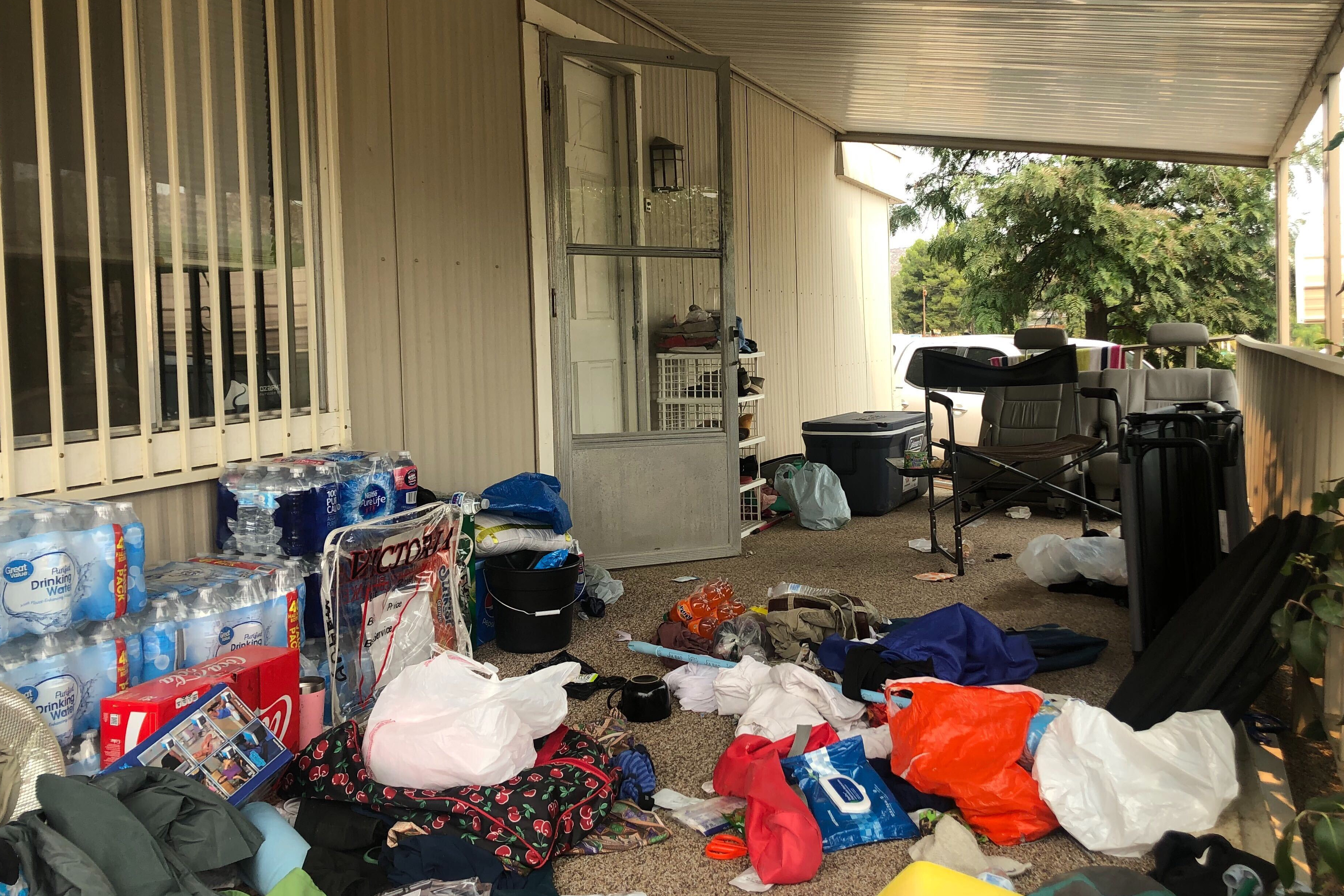 FILE - Cases of bottled water are seen with other items left on the porch of a house where killings occurred related to a Marijuana growing operation in Aguanga ,Calif., Tuesday, Sept. 8, 2020. (AP Photo/Elliot Spagat, File)