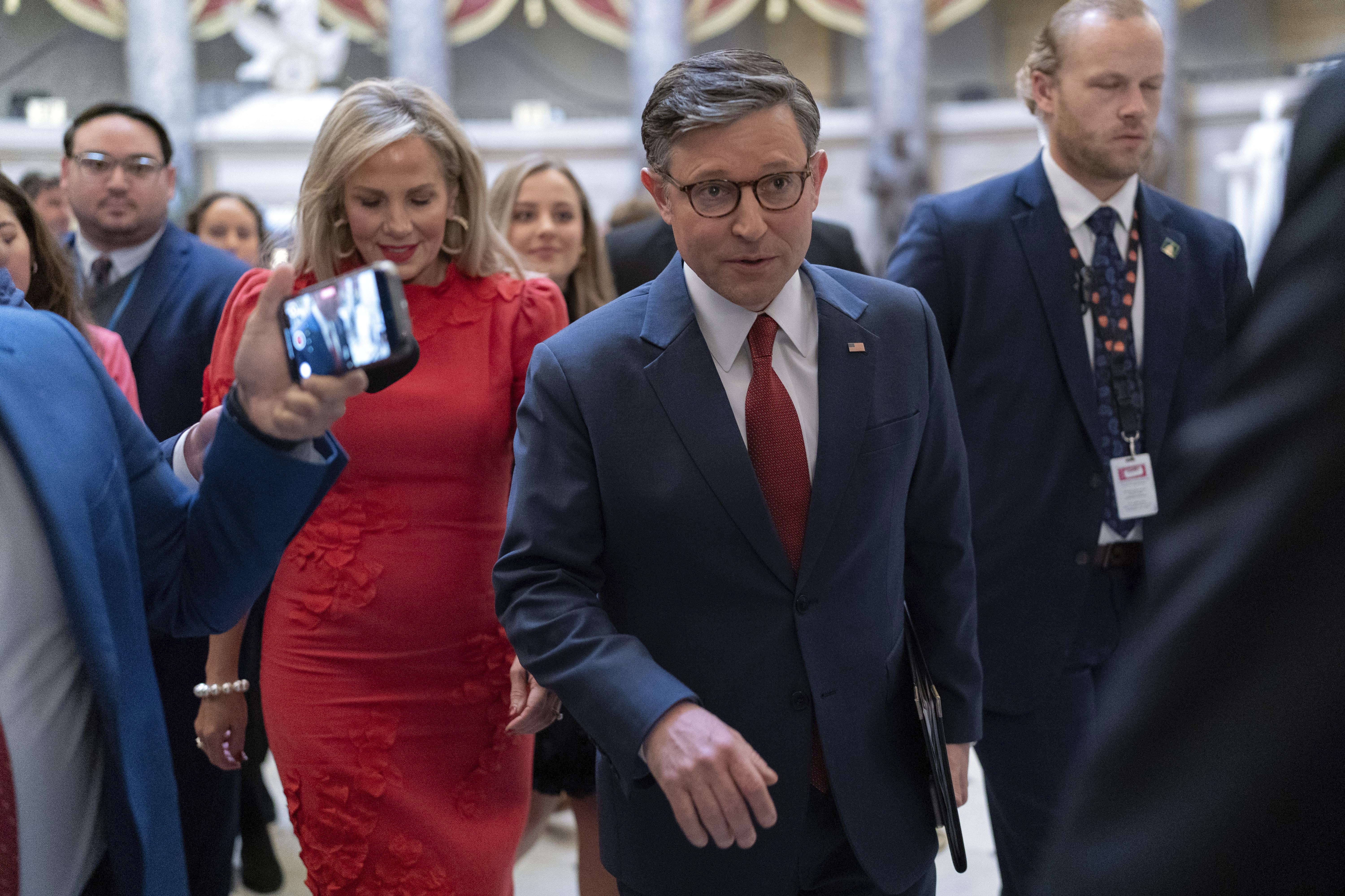 Speaker of the House Mike Johnson, R-La., accompanied by his wife Kelly Johnson, left, walks to the House Chamber before starting the 119th United States Congress at the Capitol in Washington, Friday, Jan. 3, 2025. (AP Photo/Jose Luis Magana)