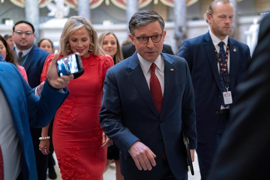 Speaker of the House Mike Johnson, R-La., accompanied by his wife Kelly Johnson, left, walks to the House Chamber before starting the 119th United States Congress at the Capitol in Washington, Friday, Jan. 3, 2025. (AP Photo/Jose Luis Magana)