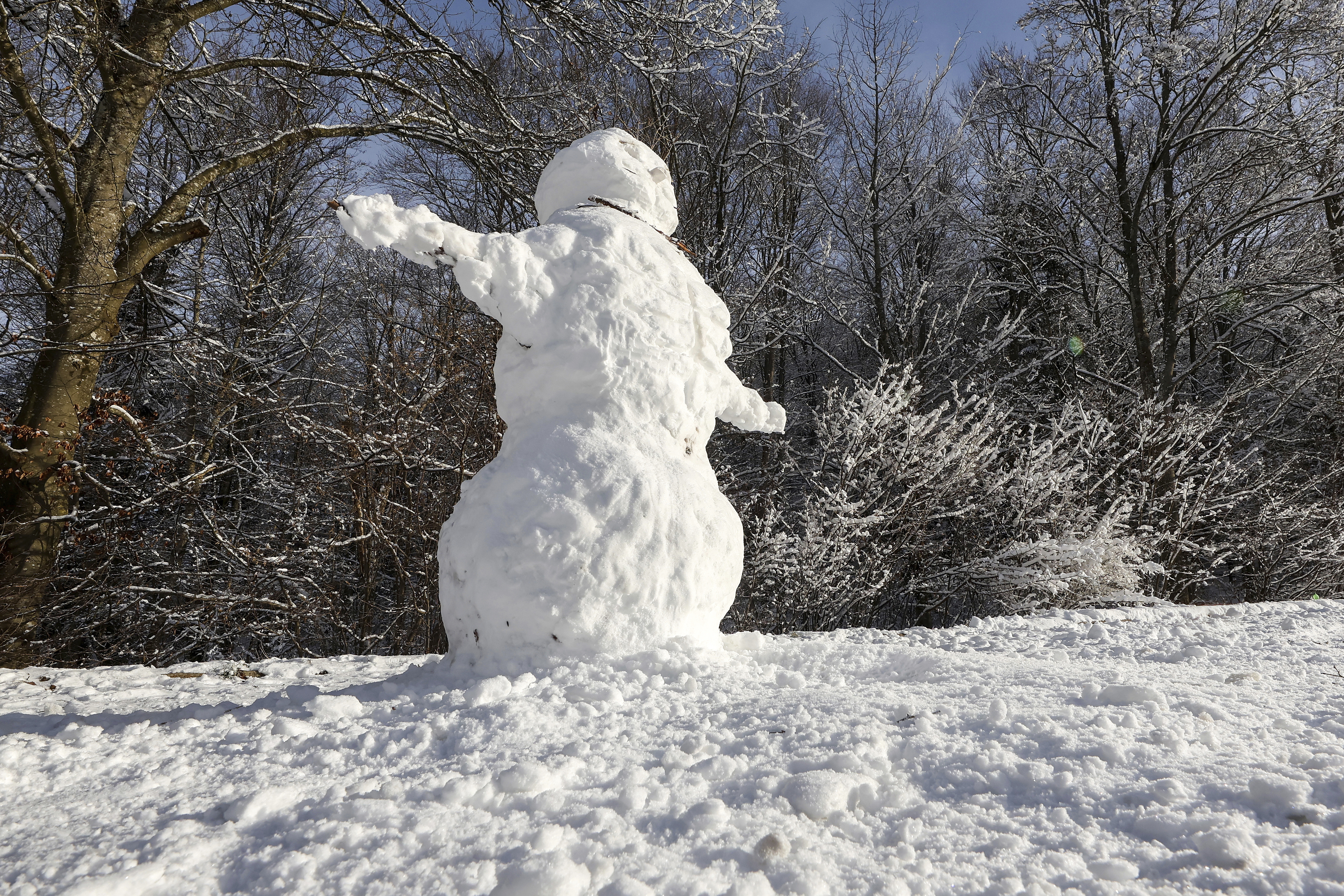 A snowman in the sunshine on the Swabian Alb, Lichtenstein, Saturday Jan. 4, 2025. (Thomas Warnack/dpa via AP)