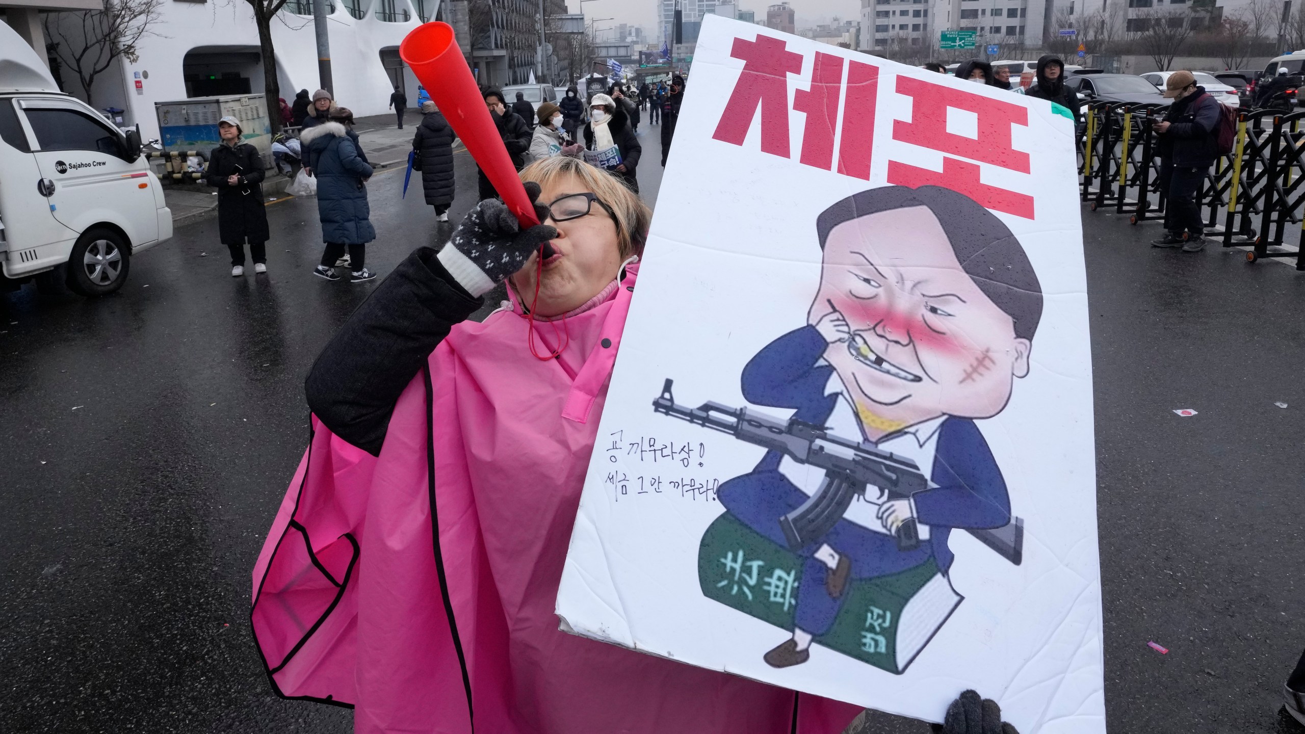 A protester blows a vuvuzela during a rally demanding the arrest of impeached South Korean President Yoon Suk Yeol near the presidential residence in Seoul, South Korea, Monday, Jan. 6, 2025. The letters read "Arrest Yoon Suk Yeol." (AP Photo/Ahn Young-joon)