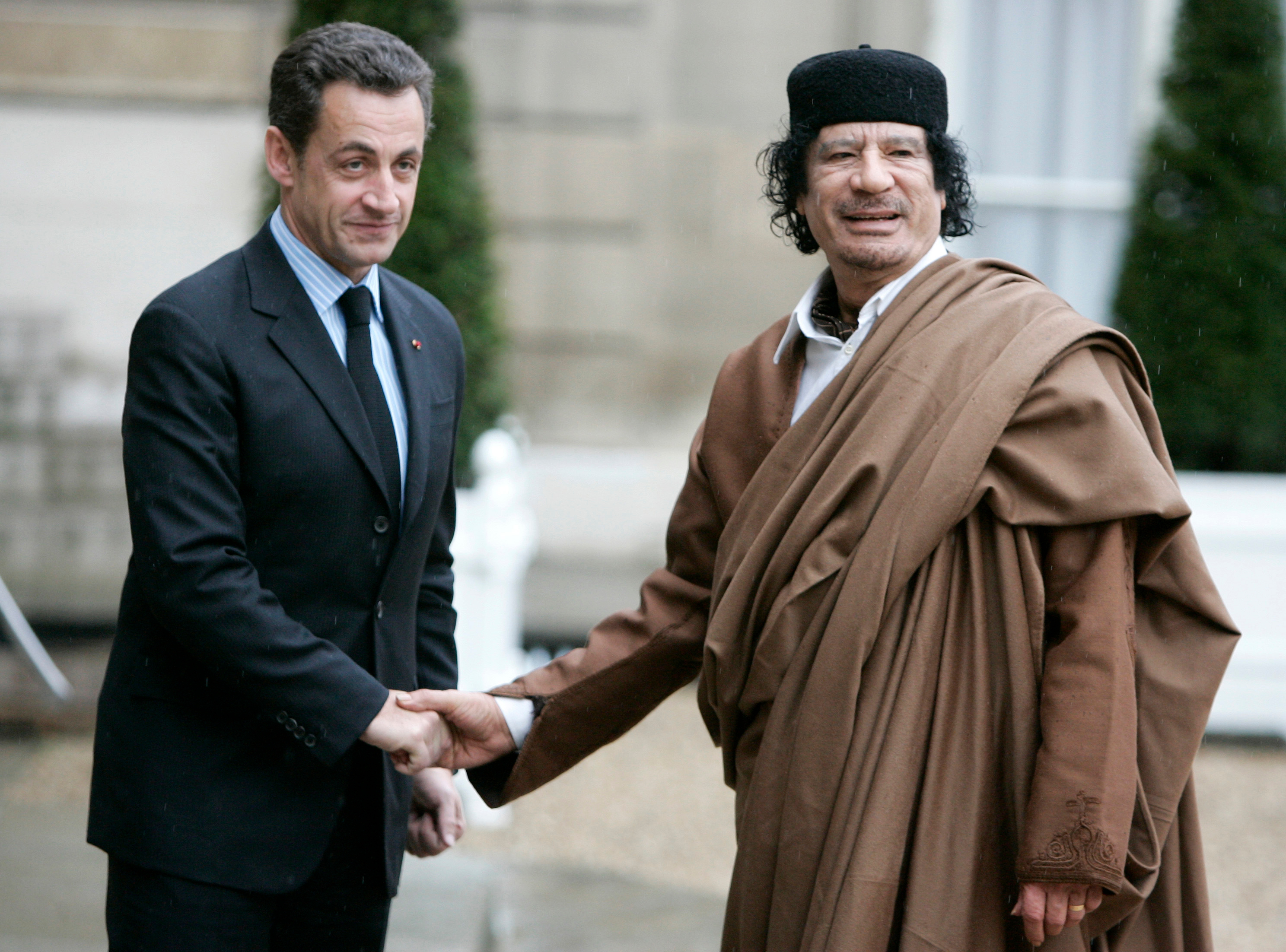 FILE - French President Nicolas Sarkozy, left, greets Libyan leader Col. Moammar Gadhafi upon his arrival at the Elysee Palace, Dec. 10 2007 in Paris. France's former President Nicolas Sarkozy goes on trial Monday Jan.6, 2025 over alleged illegal financing of his 2007 presidential campaign by the government of late Libyan leader Moammar Gadhafi. (AP Photo/Francois Mori, File)