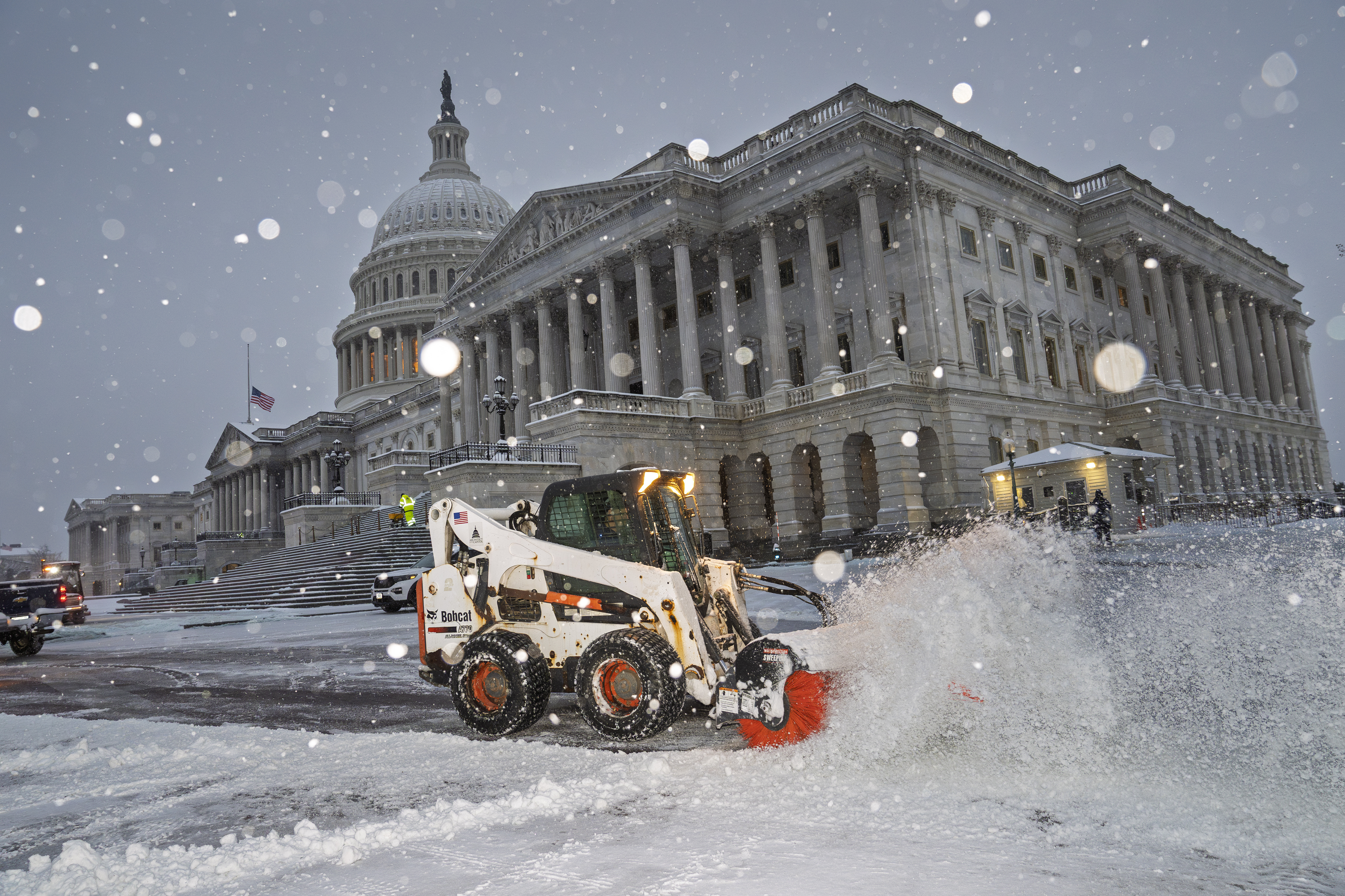 Workers clear the plaza at the Capitol as snow falls ahead of a joint session of Congress to certify the votes from the Electoral College in the presidential election, in Washington, Monday, Jan. 6, 2025. (AP Photo/J. Scott Applewhite)