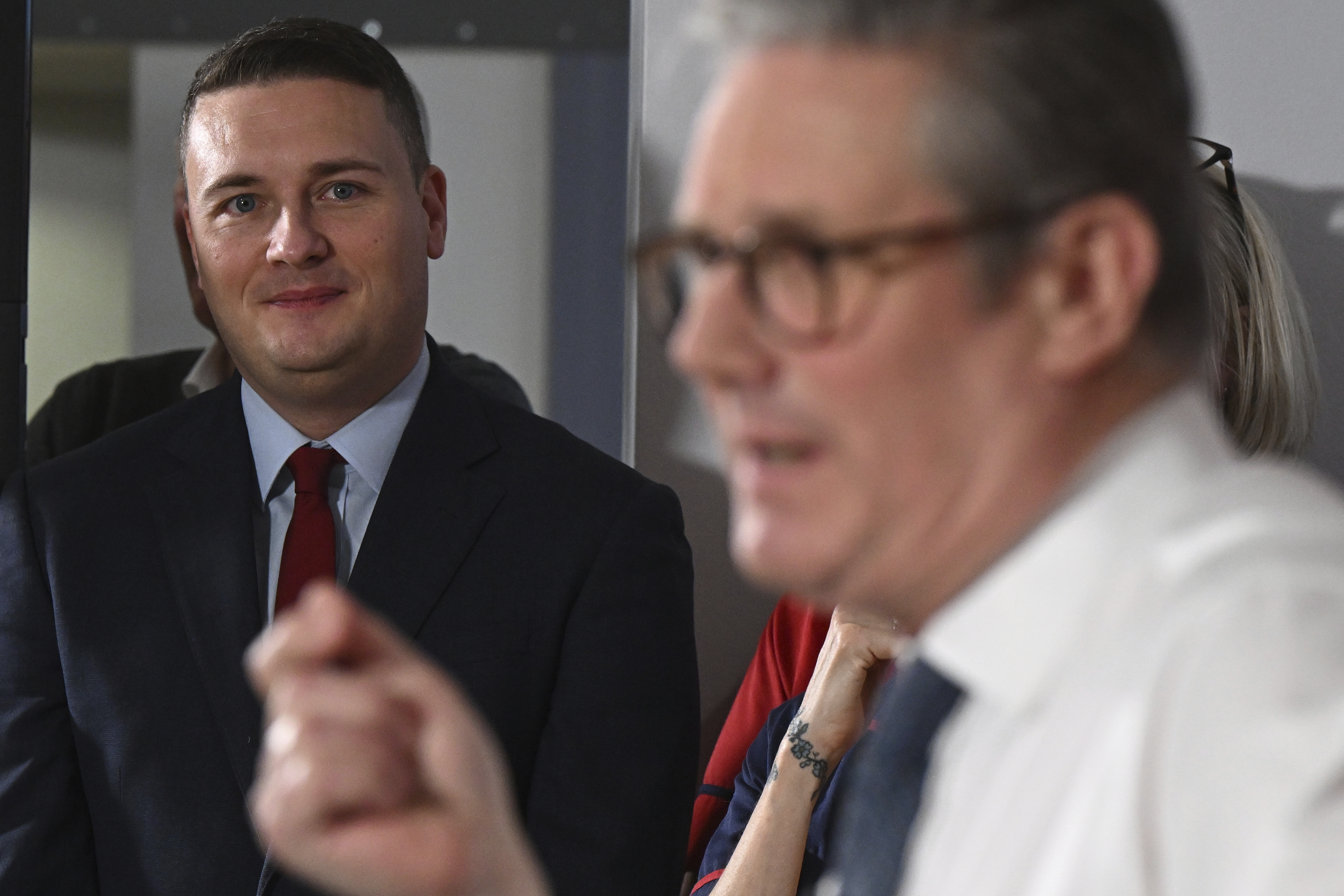 Britain's Health Secretary Wes Streeting, left, watches as Britain's Prime Minister Keir Starmer gives a speech on reducing NHS wait times as he visits a healthcare provider in Surrey, England, Monday, Jan. 6, 2025, (Leon Neal/Pool Photo via AP)