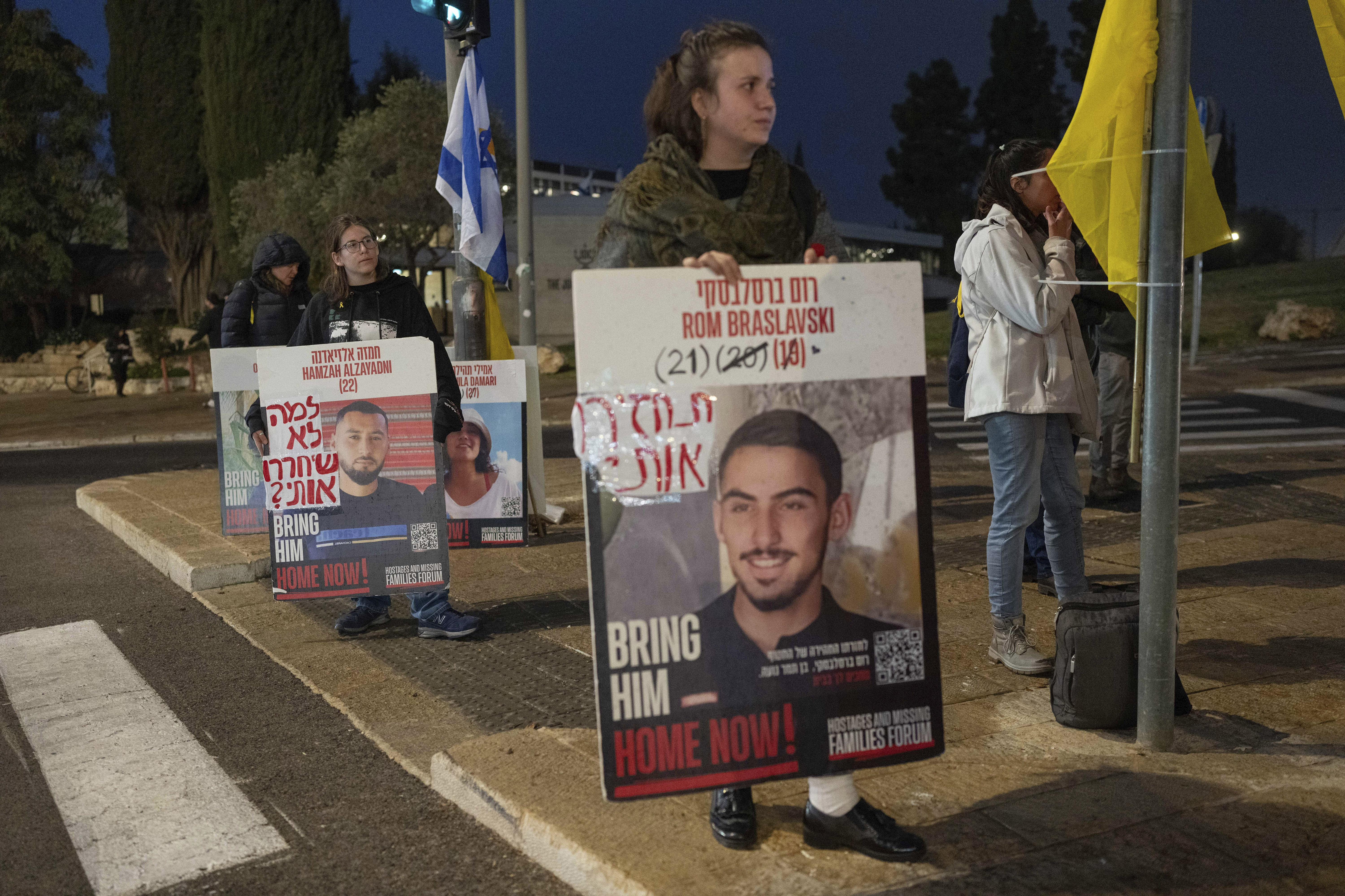 Israeli demonstrators outside the prime minister's office in Jerusalem hold photos of the hostages during a protest calling for the release of hostages held in the Gaza Strip by the Hamas militant group, Sunday, Jan. 5, 2025. (AP Photo/Ohad Zwigenberg)