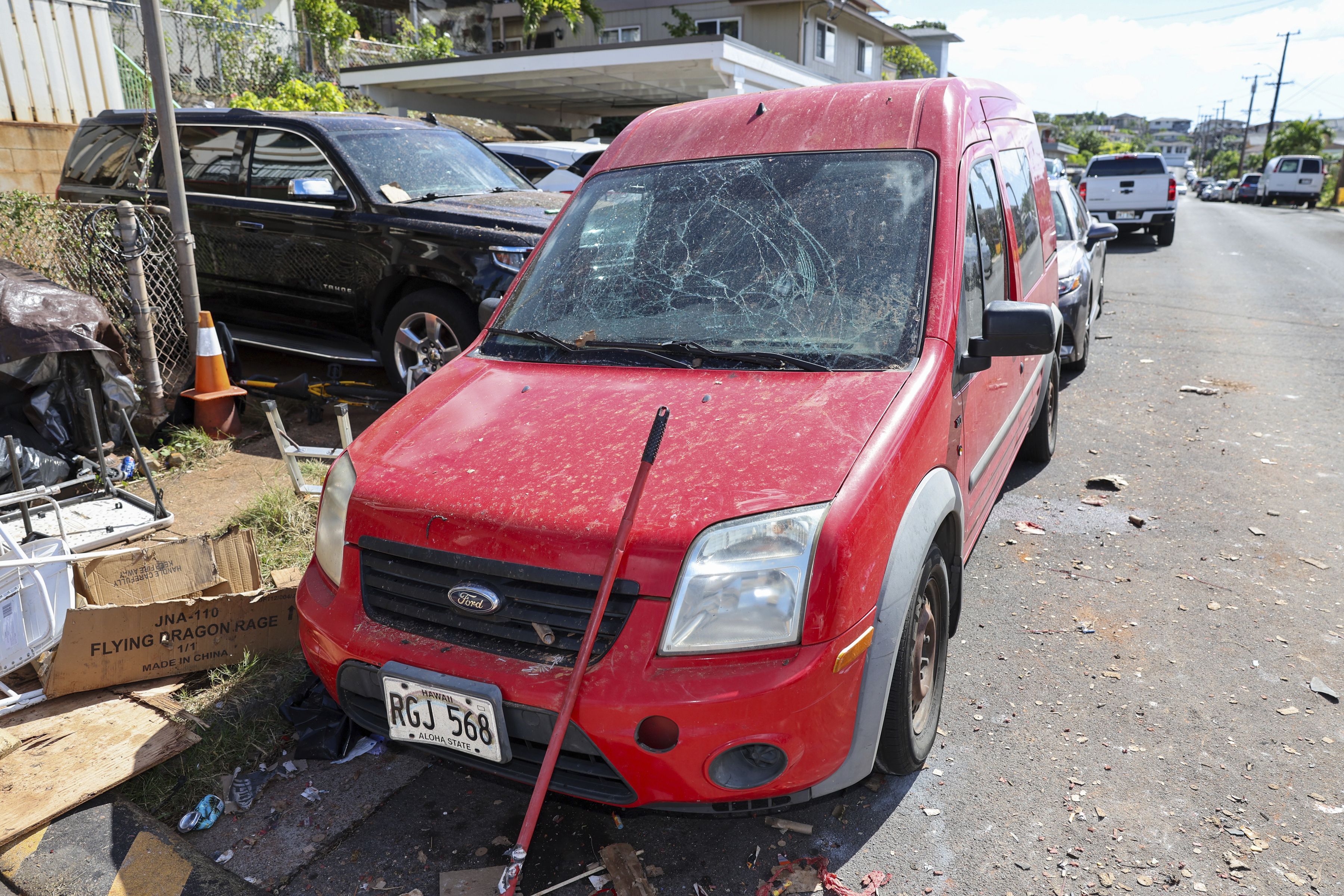 A damaged vehicle is seen near the home where a New Year's Eve fireworks explosion killed and injured people, Wednesday, Jan. 1, 2025, in Honolulu. (AP Photo/Marco Garcia)